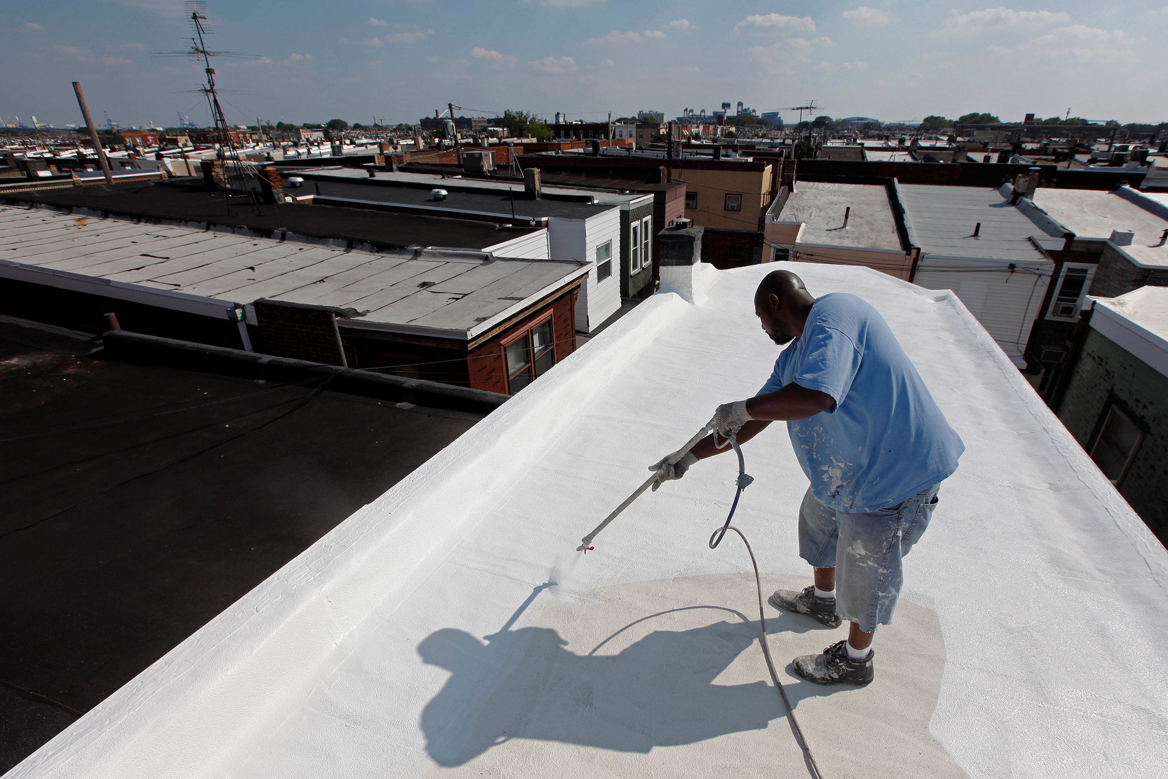 James Peterson with Bio Neighbors applies a coating of Acrymax to the roof of a row home in Philadelphia in August 2010. The idea of painting roofs white has become something of a social movement, one that many believe could be a huge help in stopping global warming. (Matt Rourke—AP)