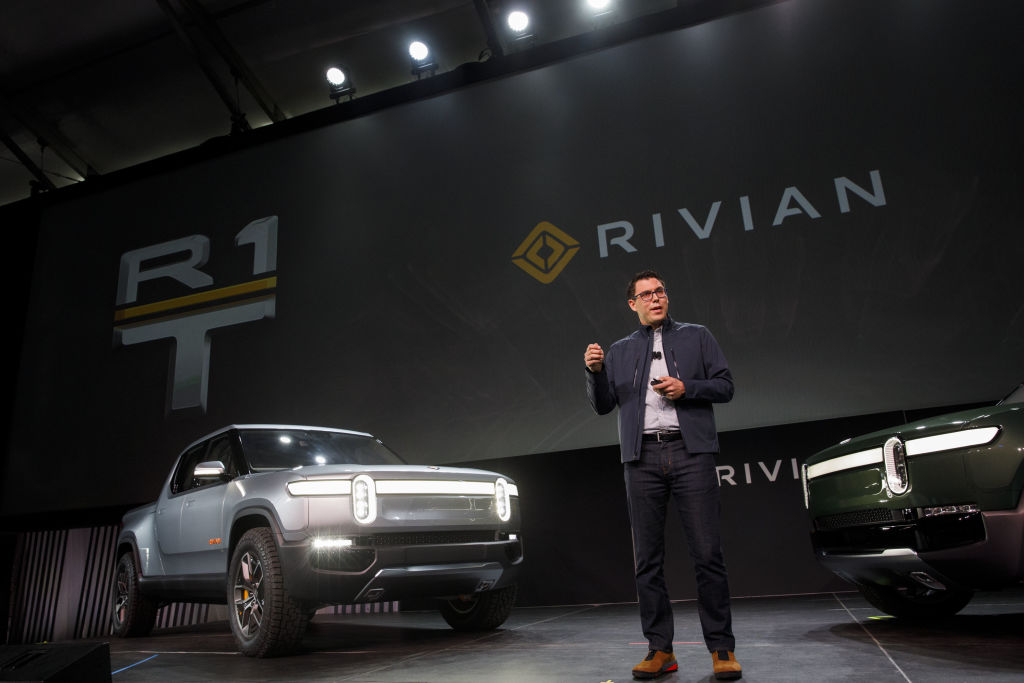 RJ Scaringe, founder and chief executive officer of Rivian Automotive Inc., unveils the R1T electric pickup truck, left, and R1S electric sports utility vehicle (SUV) during a reveal event at AutoMobility LA ahead of the Los Angeles Auto Show in Los Angeles, California, U.S., on Tuesday, Nov. 27, 2018. With its crew-cab and short bed, the R1T seems to be taking aim at the Ford F-150 Raptor. Photographer: Patrick T. Fallon/Bloomberg via Getty Images (Getty Images)