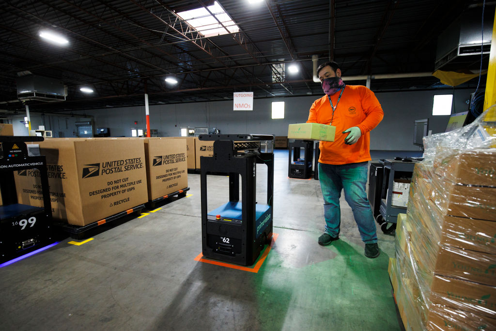 Newly implemented sorting robots are loaded by an employee during a media tour of a United States Postal Service package support annex in La Vergne, Tennessee, on November 4, 2021. (Brett Carlsen—Getty Images)