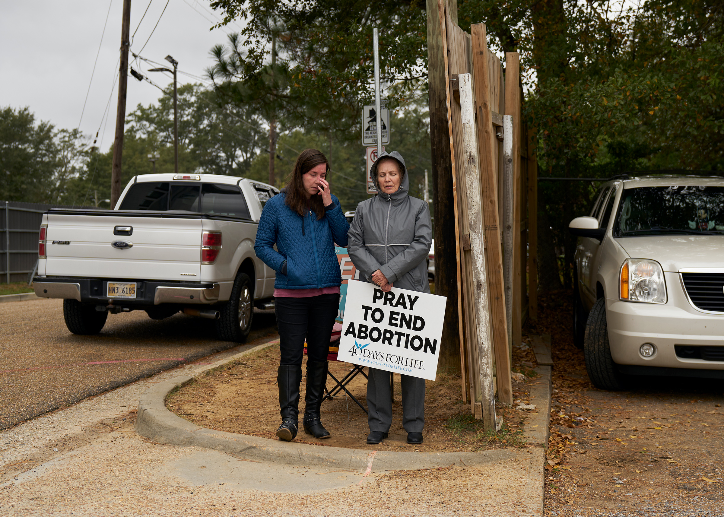 Two people stand outside Jackson Women's Health Organization holding anti-abortion signs (Stacy Kranitz for TIME)