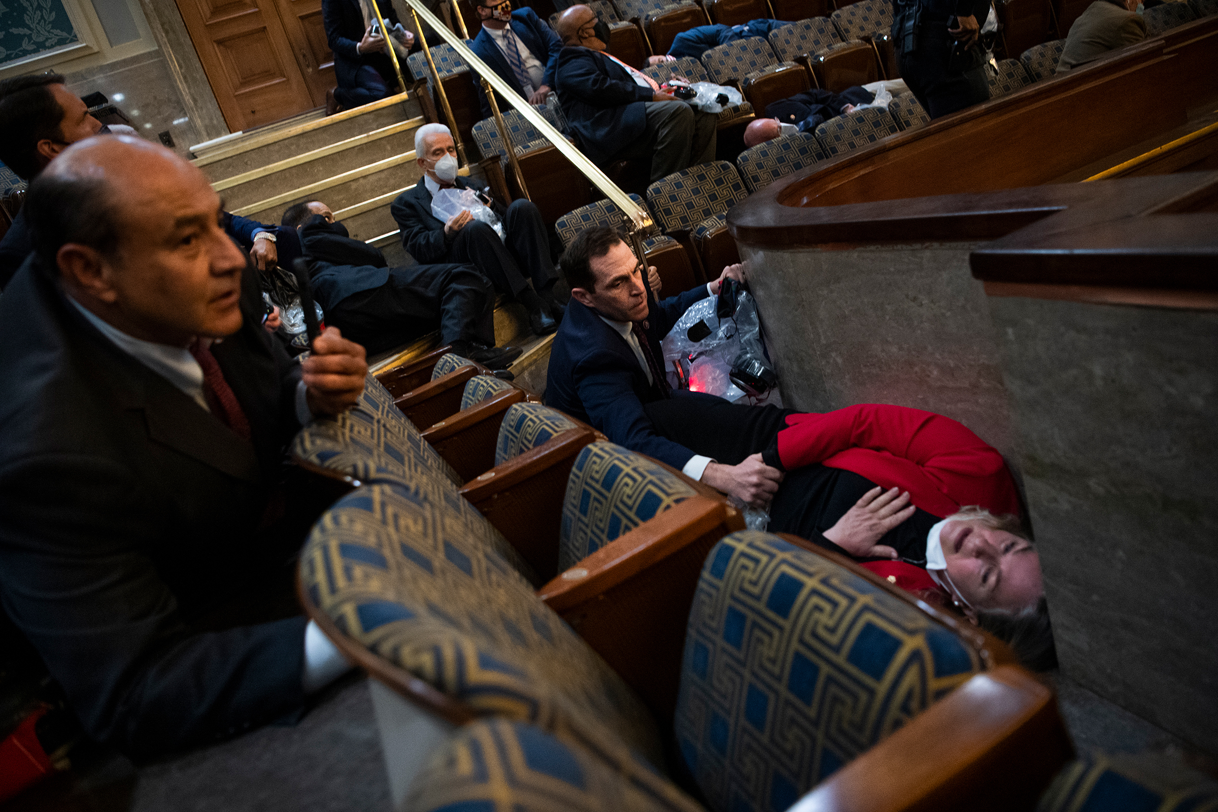 Rep. Jason Crow, D-Colo., comforts Rep. Susan Wild, D-Pa., while taking cover during the attack at the Capitol on Jan. 6. (Tom Williams—CQ-Roll Call, Inc./Getty Images)