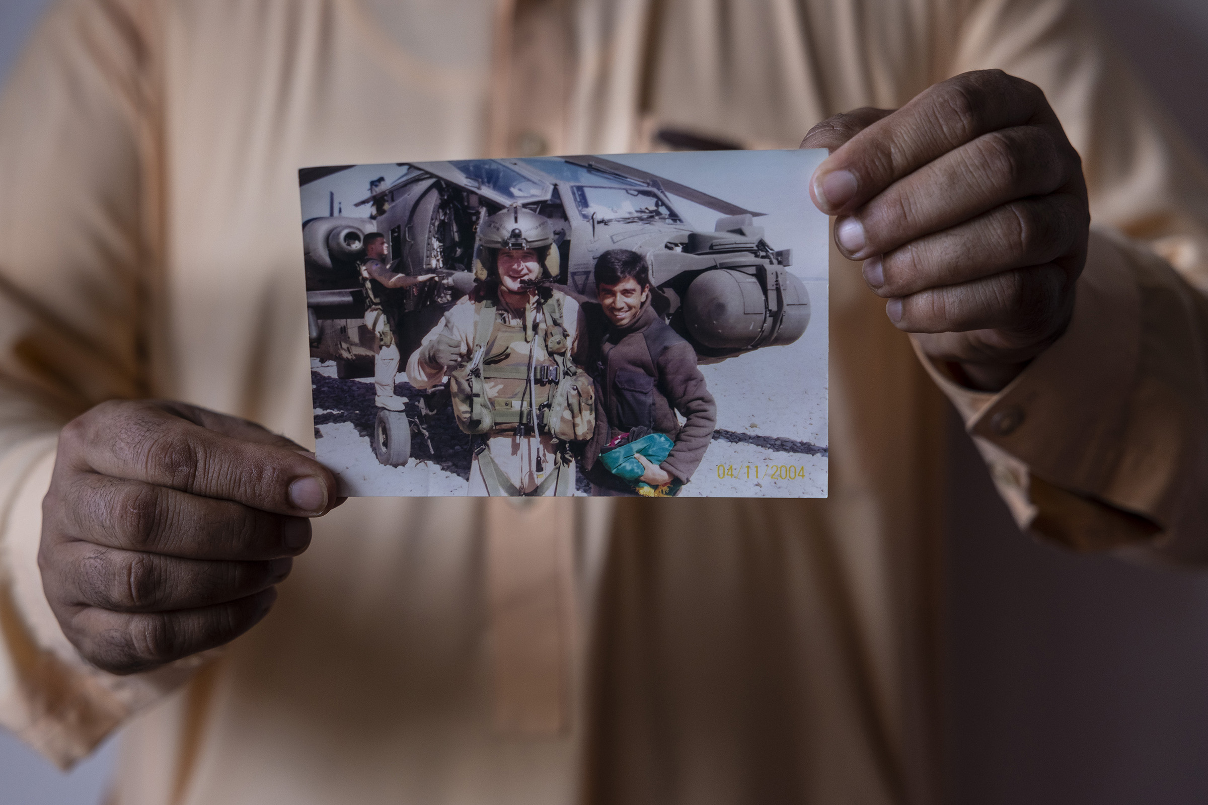 Special Immigrant Visa (SIV) applicant Mohammed Arif Ahmadzai, 41, holds an image of himself with US military personnel while at his home on August 1, 2021 in Kabul, Afghanistan. Mohammed worked for almost 8 years as a combat translator from 2003-2010 for the US Army, the Marines as well as on the Provincial Reconstruction Team (PRT) and the Special Forces in Kunar province. He applied for the the Special Immigrant Visa (SIV) paying the visa and medical fees costing him over $2,000 but was denied in 2014 without what he viewed as sufficient explanation. He is currently appealing his case. (Paula Bronstein-Getty Images)