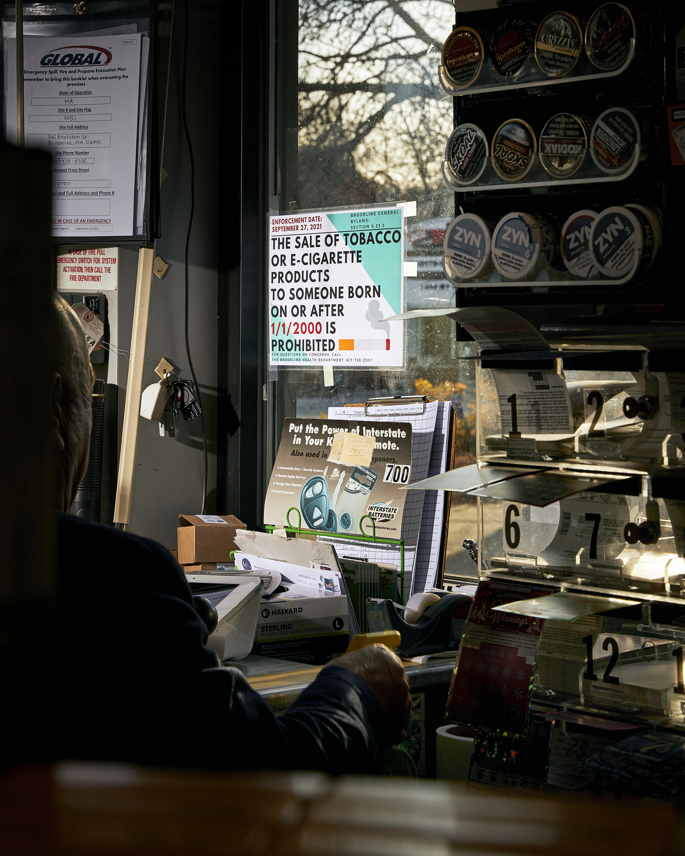 Elias Audy is one of several convenience store owners suing Brookline over its tobacco-free generation policy. He is photographed inside his Village Mobil store, where a sign displays information about the new tobacco ban. (Cody O'Loughlin for TIME.)