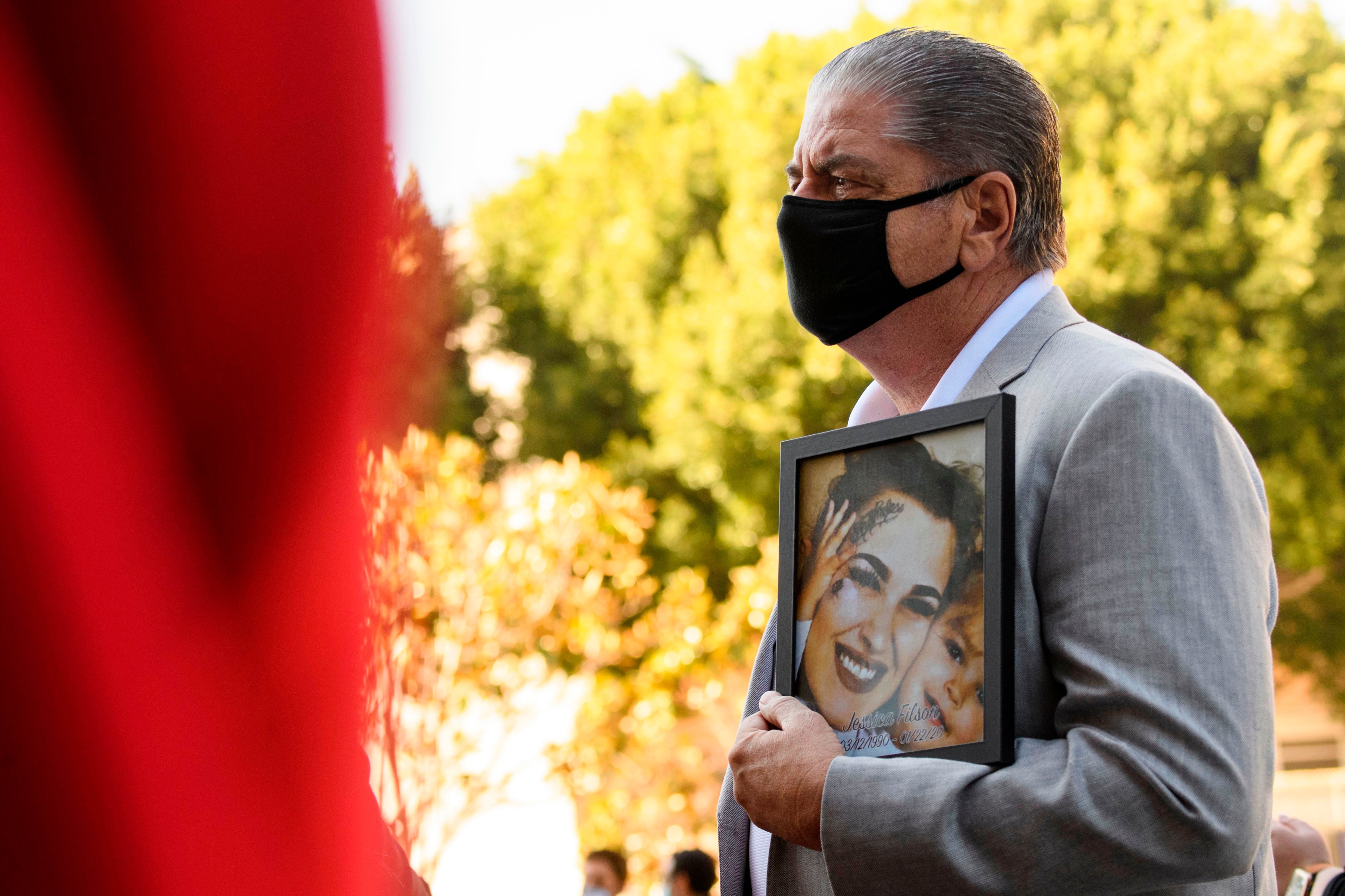 Steve Filson carries a photo of his daughter Jessica Filson, who died in January 2020 of opioids, during a news conference outside the Roybal Federal Building on February 24 in Los Angeles, California. (PATRICK T. FALLON/AFP via Getty Images)