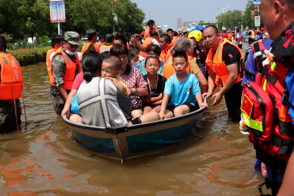 Rescuers evacuate people from a flooded part of Weihui city in central China's Henan province, on Monday, July 26, 2021. (Feature China/Barcroft Media via Getty Images)