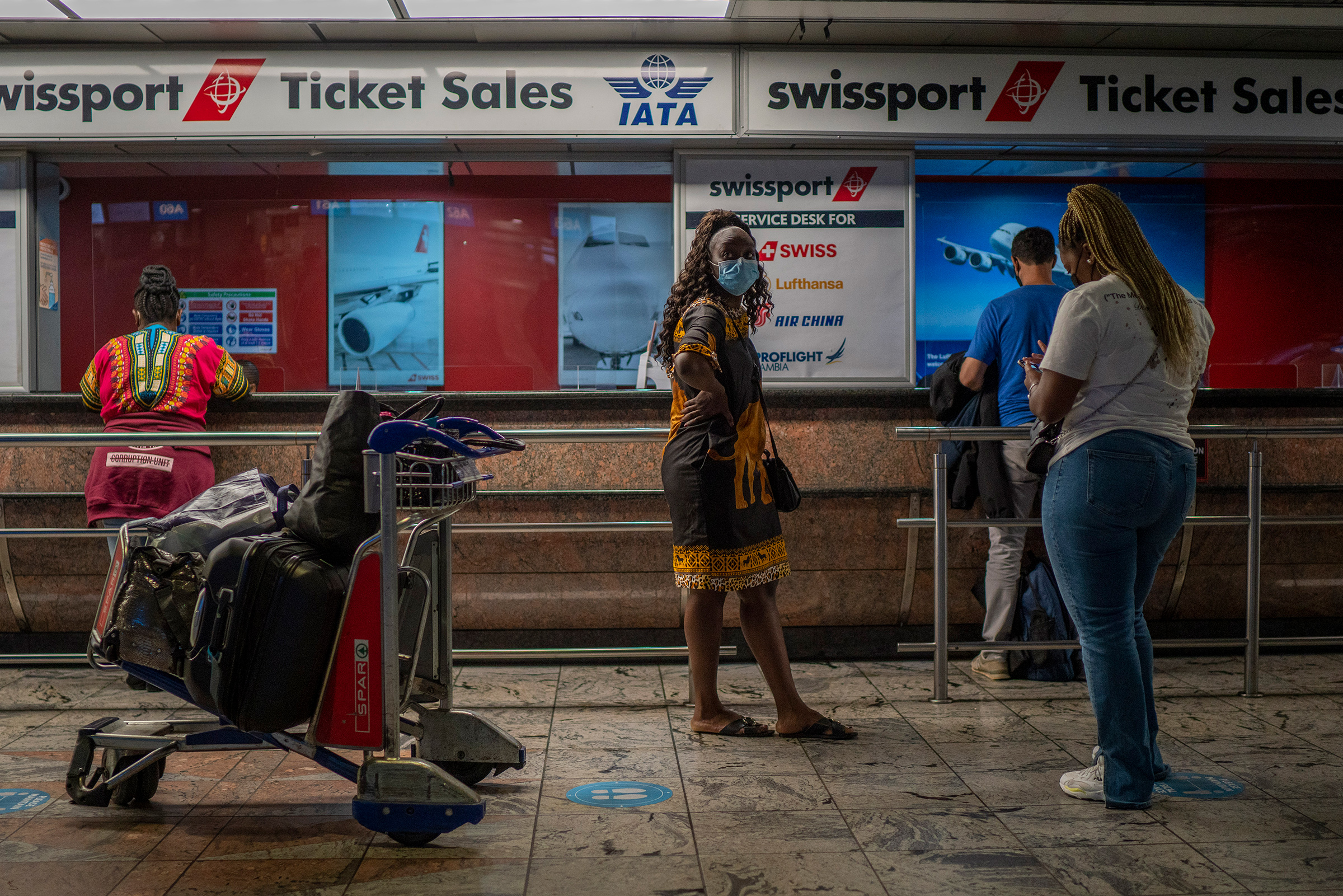 Passengers wait at a ticket counter at Johannesburg's O.R. Tambo's airport on Nov. 29. A pandemic-weary world faces weeks of confusing uncertainty as countries restrict travel and take other steps to halt the newest potentially risky coronavirus mutant before anyone knows just how dangerous omicron is. (Jerome Delay—AP)