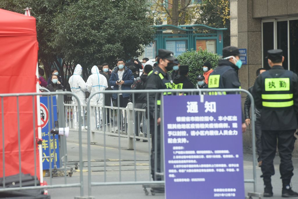 Security personnel lock down a residential block where a COVID-19 case was found in Hangzhou in eastern China's Zhejiang province Wednesday, Dec. 8, 2021. (Long Wei—Future Publishing/Getty Images)
