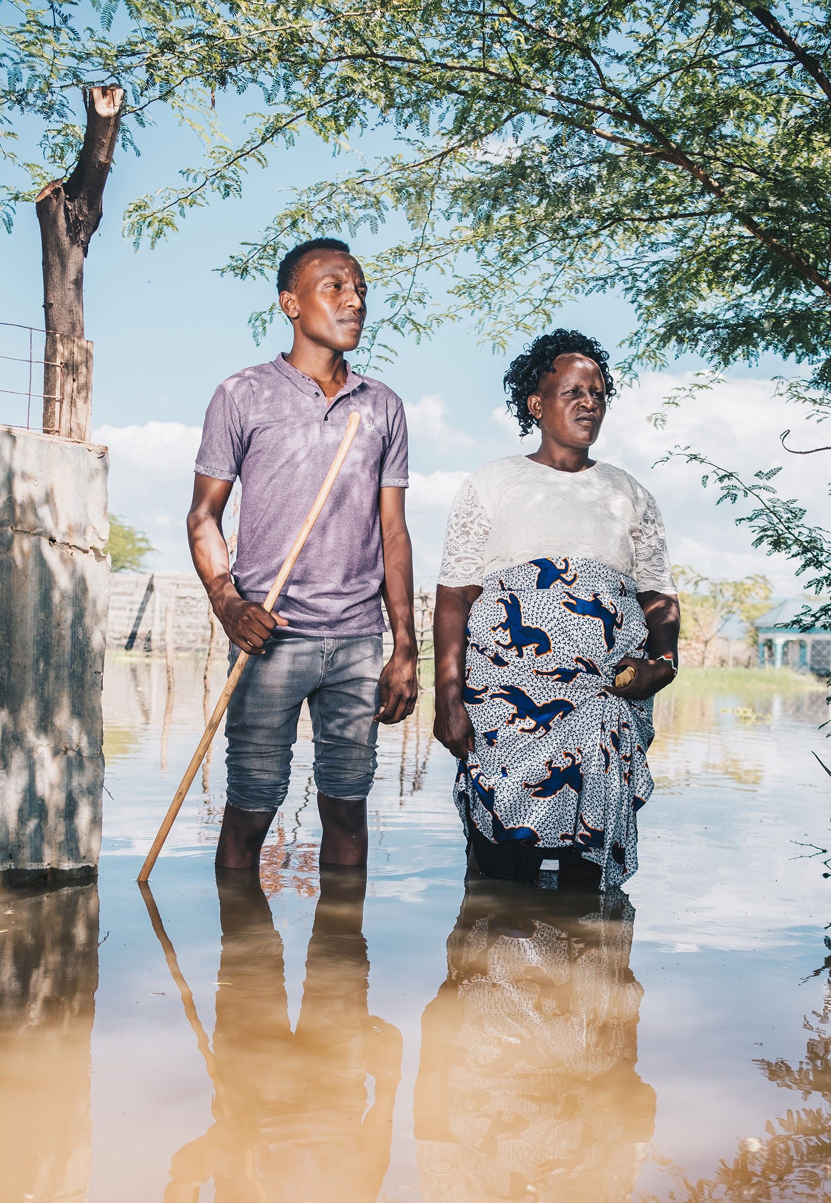 <strong>Festus and Veronica Parkolwa</strong> stand at the entrance of their former home by Lake Baringo. "<a href="https://time.com/5953402/climate-migrants-kenya-floods/">Environmental Crises Are Forcing Millions Into Cities. Can Countries Turn Climate Migrants Into an Asset?</a>" April 26 issue. (Khadija Farah for TIME)