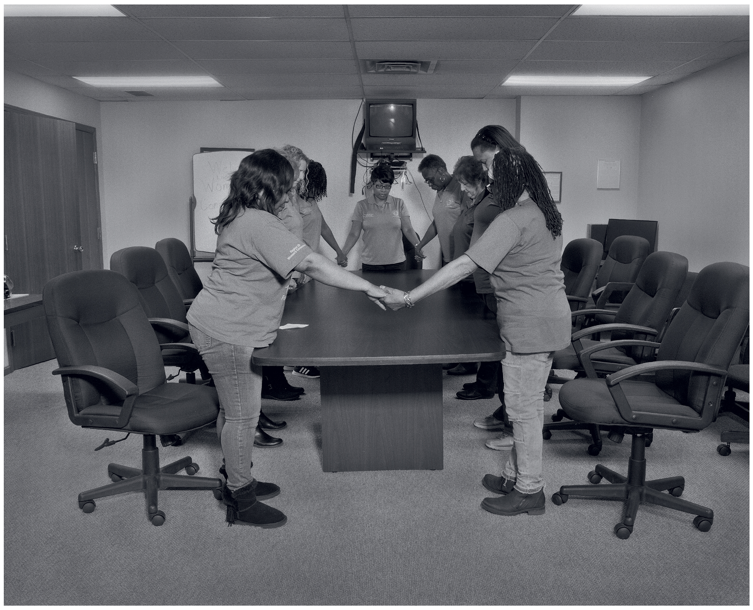 Women's Committee final gathering inside their conference room at UAW Local 1112 Reutehr Scandy Alli union hall (left to right, Crystal Carpenter, Linda Hash, Trisha Brown, RaNeal Edwards, Pamela Brown, Marilyn Moore, Mary Ola Stemple, Tunisha Bell, and Frances Turnage), Lordstown, OH, 2019 (LaToya Ruby Frazier—The Renaissance Society, University of Chicago)