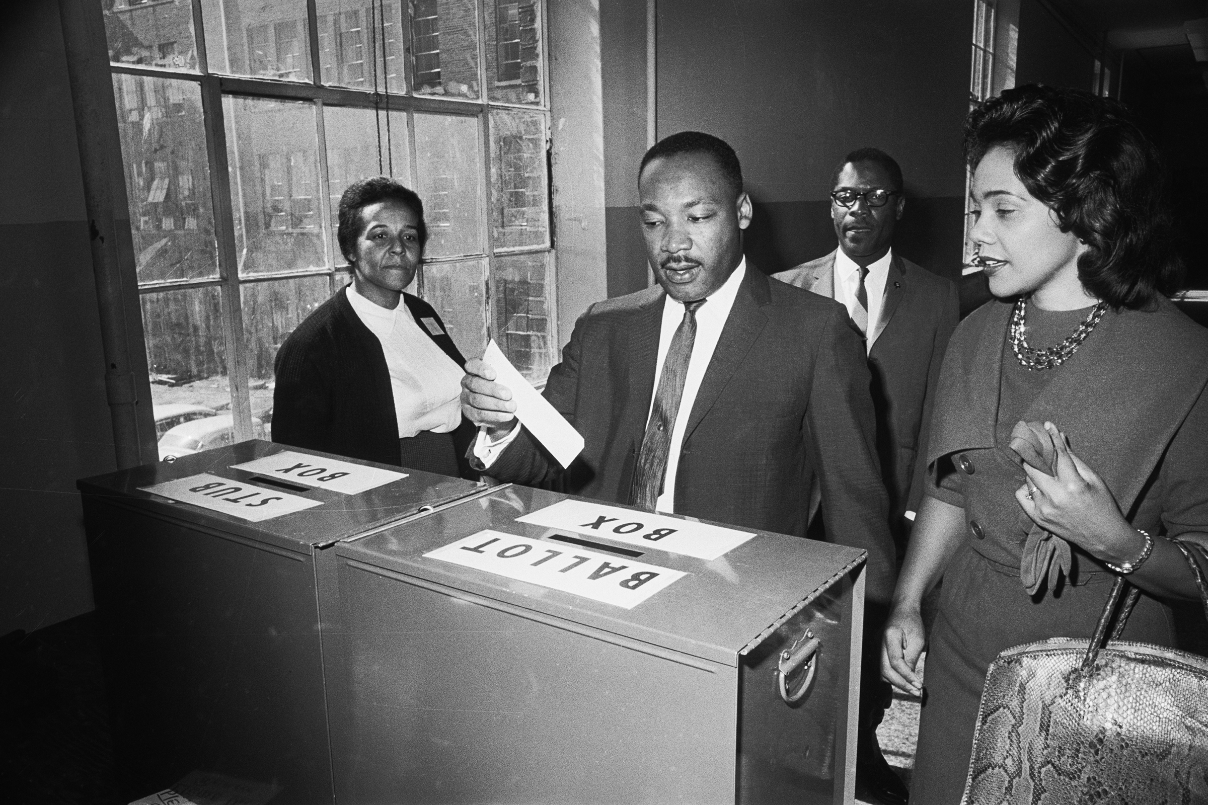 Dr Martin Luther King Jr votes as his wife, Coretta Scott King, waits her turn. November 3rd, 1964. Atlanta, GA. (Bettmann Archive)