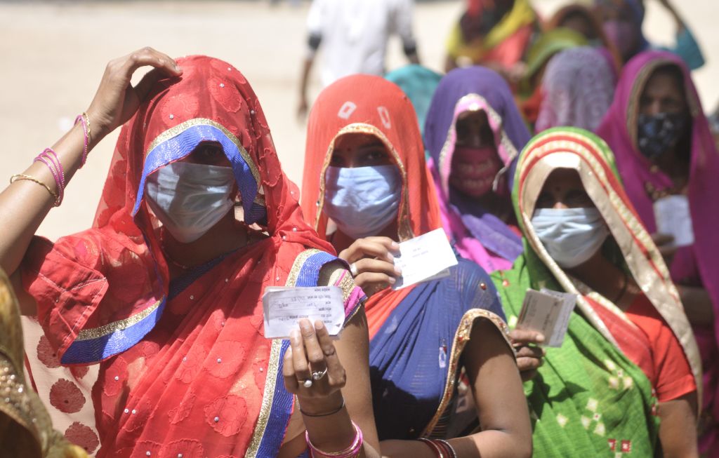 Women show voter ID cards during Panchayat election, at Bakkas polling centre on April 19, 2021 in Lucknow, India. (Deepak Gupta/Hindustan Times via Getty Images)