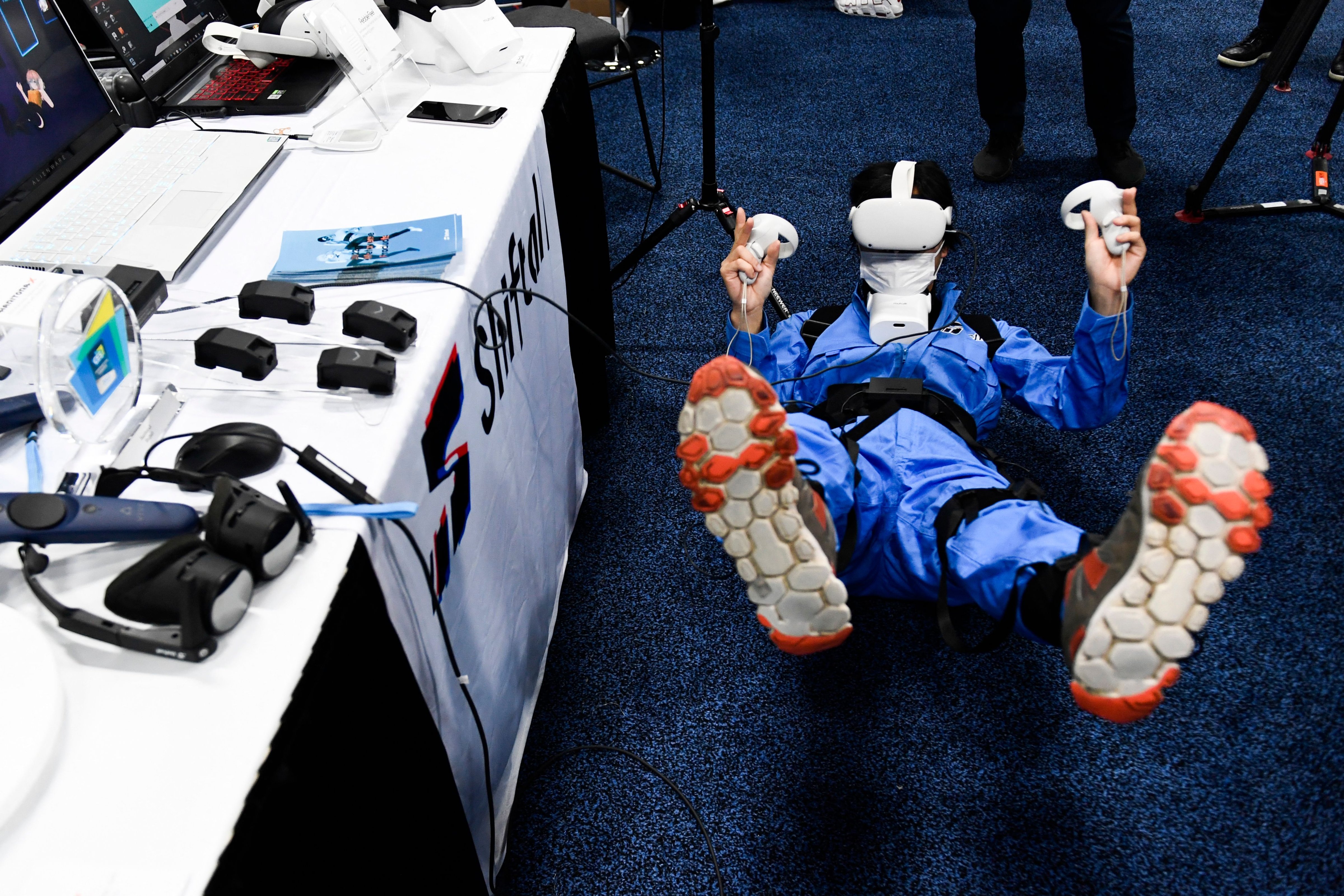 An attendee tries out the Shiftall Haritora X full-body tracking system and Oculus headset at CES 2022. (Patrick T. Fallon–AFP/Getty Images)