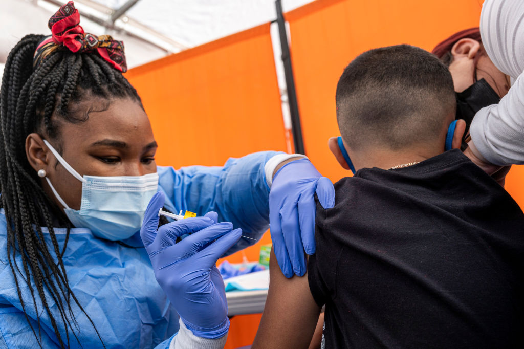 A healthcare worker administers a Pfizer-BioNTech Covid-19 vaccine to a child at a testing and vaccination site in San Francisco, California, U.S., on Monday, Jan. 10, 2022. California Governor Gavin Newsom is proposing a $2.7 billion Covid-19 emergency response package in his budget Monday to boost testing and its health-care system following a surge in cases caused by the omicron variant. (David Paul Morris-Bloomberg)