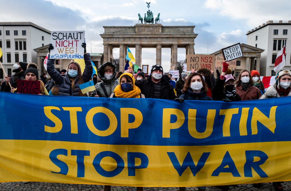 Demonstrators display a banner in the colours of the Ukrainian flag reading "Stop [Russian President] Putin, Stop war" during a protest at Berlin's Brandenburg Gate on January 30, 2022. - Demonstrators criticised Putin's massing of troops near the Ukrainian border and called on Germany to play a more active role in defending Ukraine's interests. (John MACDOUGALL-AFP)