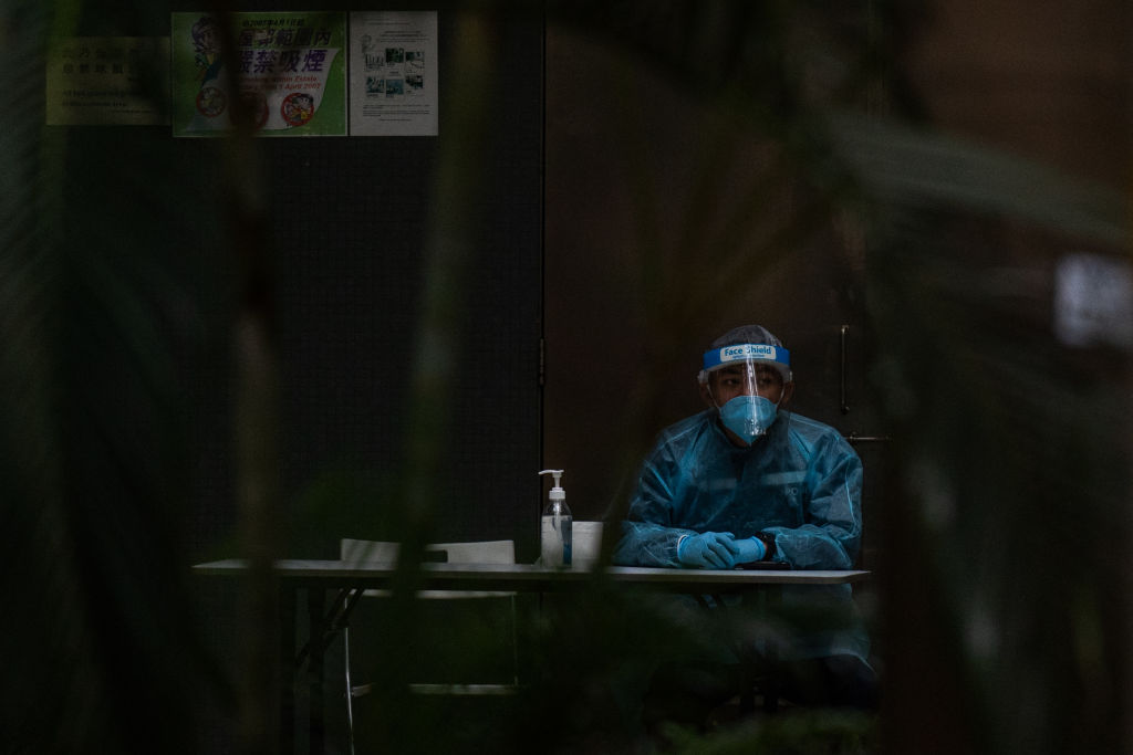 A health official wearing personal protective equipment (PPE) outside a residential building at Kwai Chung Estate public housing complex in Hong Kong, China, on Sunday, Jan. 23, 2022. The unprecedented step to place buildings at the public housing complex under lockdown is one of the most drastic measures Hong Kong has launched as it works to eradicate the virus within its borders. (Bertha Wang–Bloomberg/Getty Images)