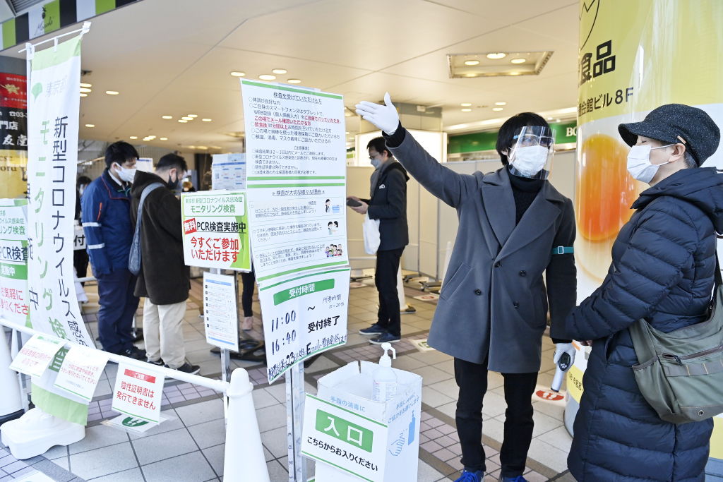 A healthcare staff worker instructs a woman at a COVID-19 test center on Jan. 17, 2022, in Tokyo. Tokyo and neighboring regions are preparing for a state of quasi-emergency due to a fast resurgence of the Omicron variant and the record levels of new infections exceeding 25,000 nationwide. (David Mareuil–Anadolu Agency/Getty Images&mdash;2022 Anadolu Agency)
