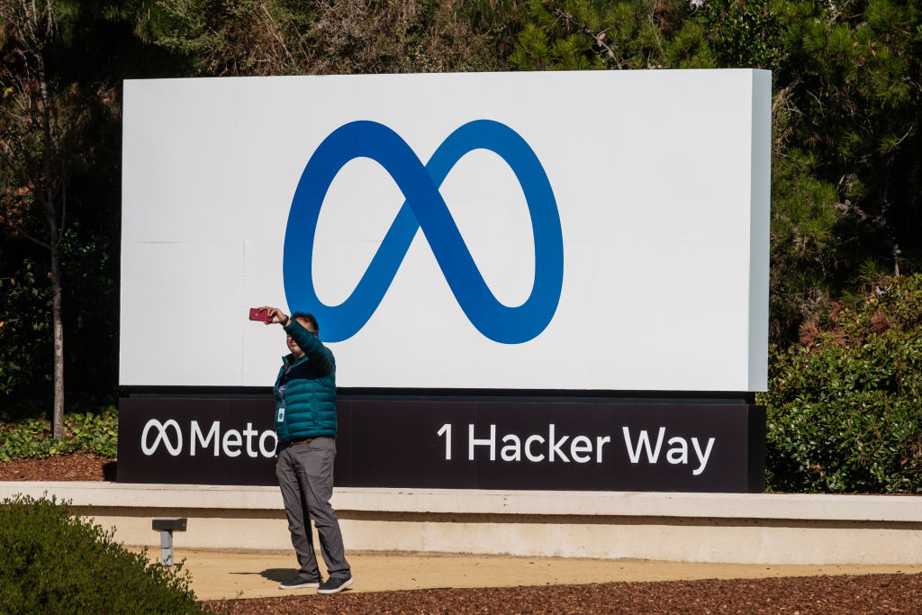 A visitor takes photographs in front of signage at Meta Platforms headquarters in Menlo Park, Calif. on Friday, Oct. 29, 2021. Facebook Inc. is re-christening itself Meta Platforms, decoupling its corporate identity from the eponymous social network mired in toxic content, and highlighting a shift to an emerging computing platform focused on virtual reality. (Nick Otto–Bloomberg/Getty Images)