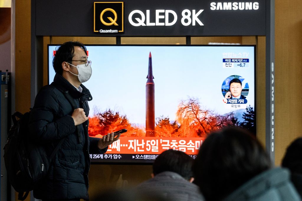 A man walks past a television screen showing a news broadcast with file footage of a North Korean missile test, at a railway station in Seoul on Jan. 11, 2022, after North Korea fired a "suspected ballistic missile" into the sea, South Korea's military said. (Anthony Wallace–AFP/Getty Images)