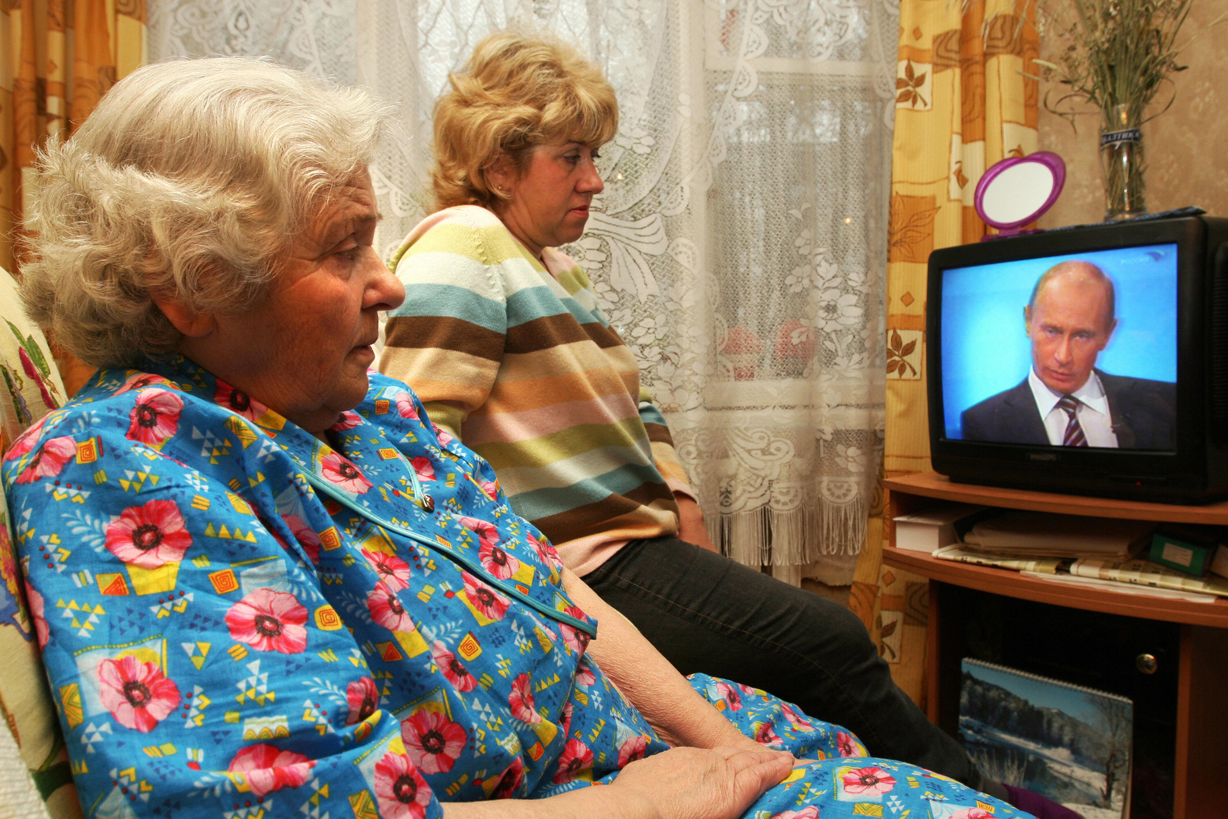 Two Russian women Olga (L) and her daughter Nadia (R) watch Russian Prime Minister Vladimir Putin taking questions during a nationally televised town-hall style session in Shcherbika on December 4, 2008. Putin ruled out early presidential elections, saying the next presidential ballot in Russia would be held as scheduled in 2012. (Andrei Smirnov —AFP/Getty Images)