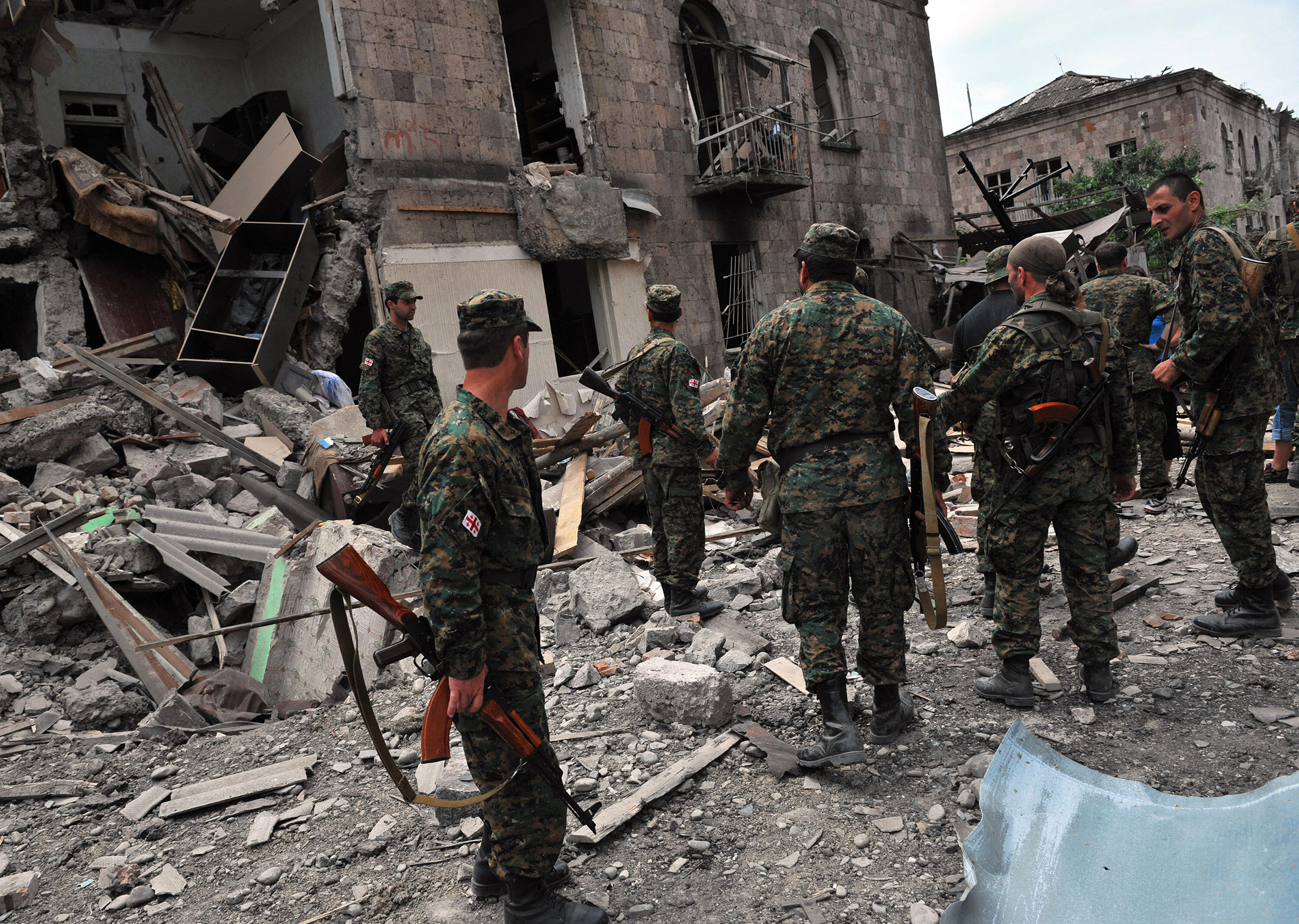 Georgian soldiers watch a building hit by bombardments in Gori on August 9, 2008. Georgian President Mikheil Saakashvili declared a "state of war" on August 9 as his troops battled it out with Russian forces over the breakaway province of South Ossetia. Russian warplanes bombed the Georgian city of Gori killing civilians. (Dimitar Dolkoff—AFP/Getty Images)
