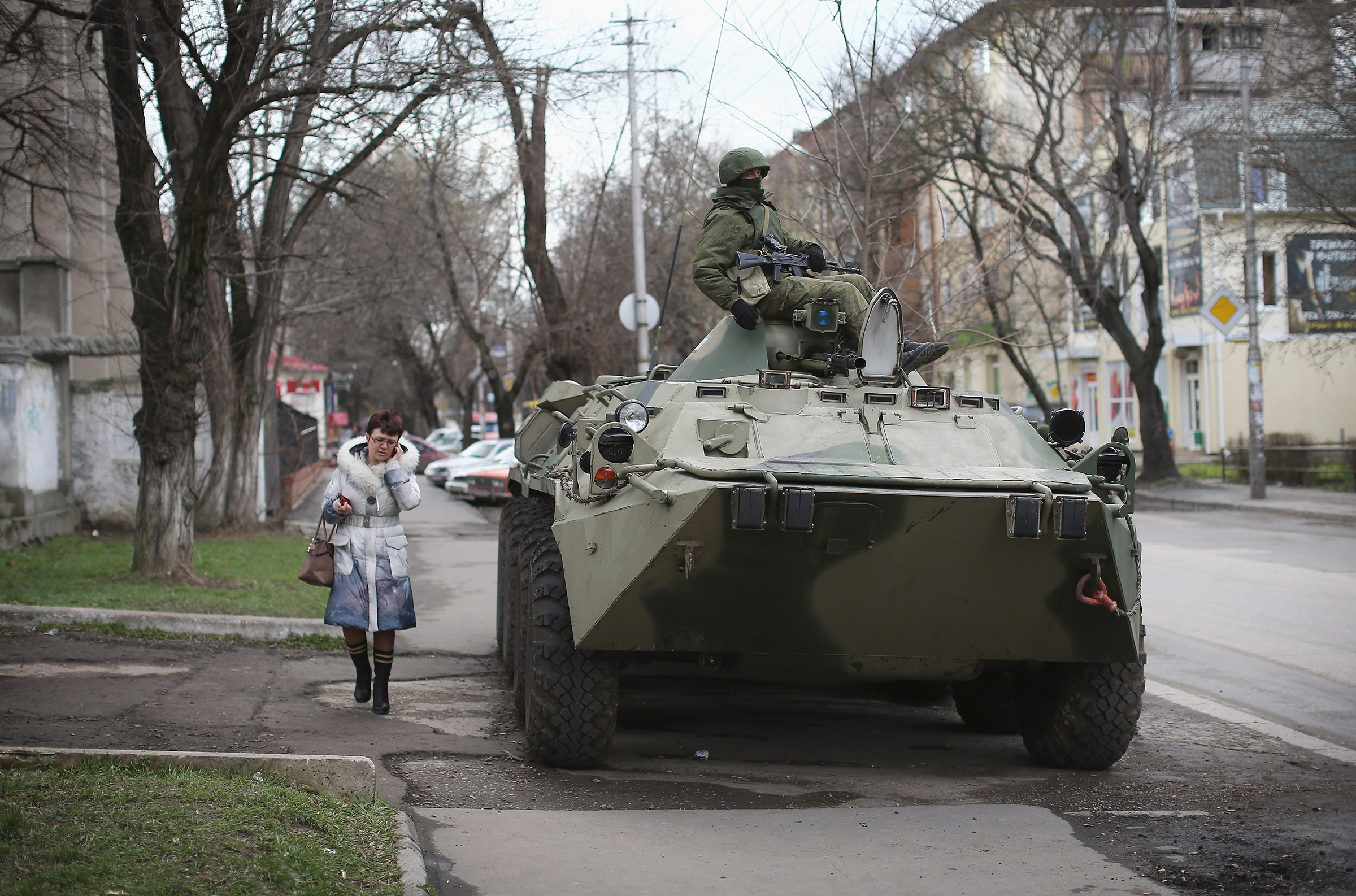 A woman walks past a Russian military personnel carrier outside a Ukrainian military base on March 18, 2014 in Simferopol, Ukraine. Voters on the autonomous Ukrainian peninsular of Crimea voted overwhelmingly yesterday to secede from their country and join Russia. (Dan Kitwood—Getty Images)