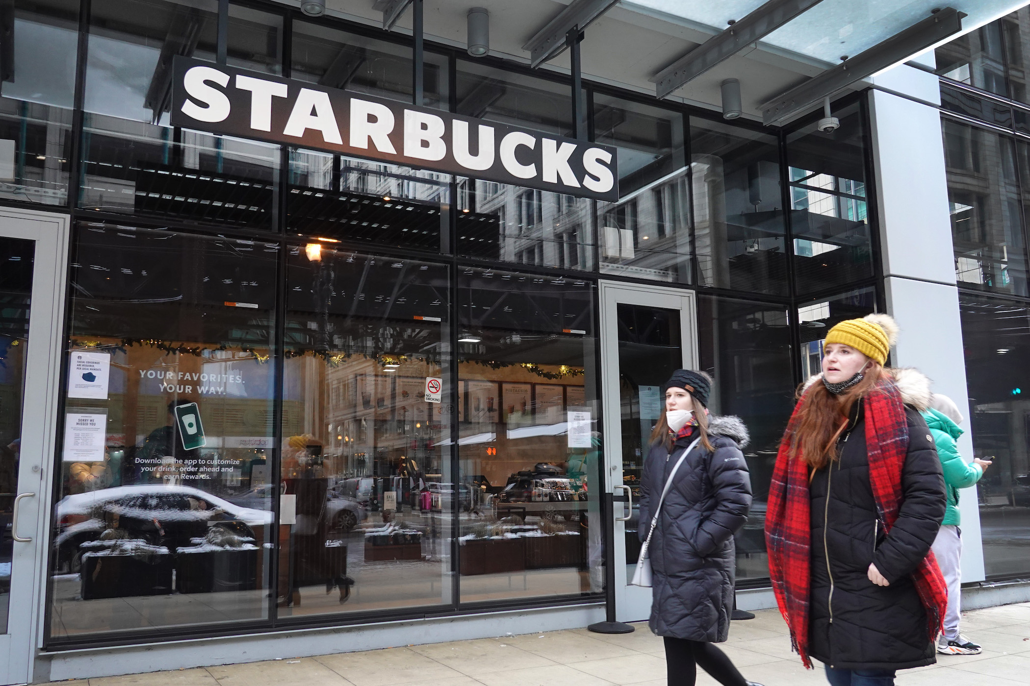 A Starbucks sign hangs above the entrance of one of the chain's coffee shops in the Loop on January 04, 2022 in Chicago, Illinois. Workers at the coffee shop have submitted signed cards seeking to join an affiliate of the Service Employees International Union (SEIU), making it the first Starbucks in the Midwest to request a union certification.