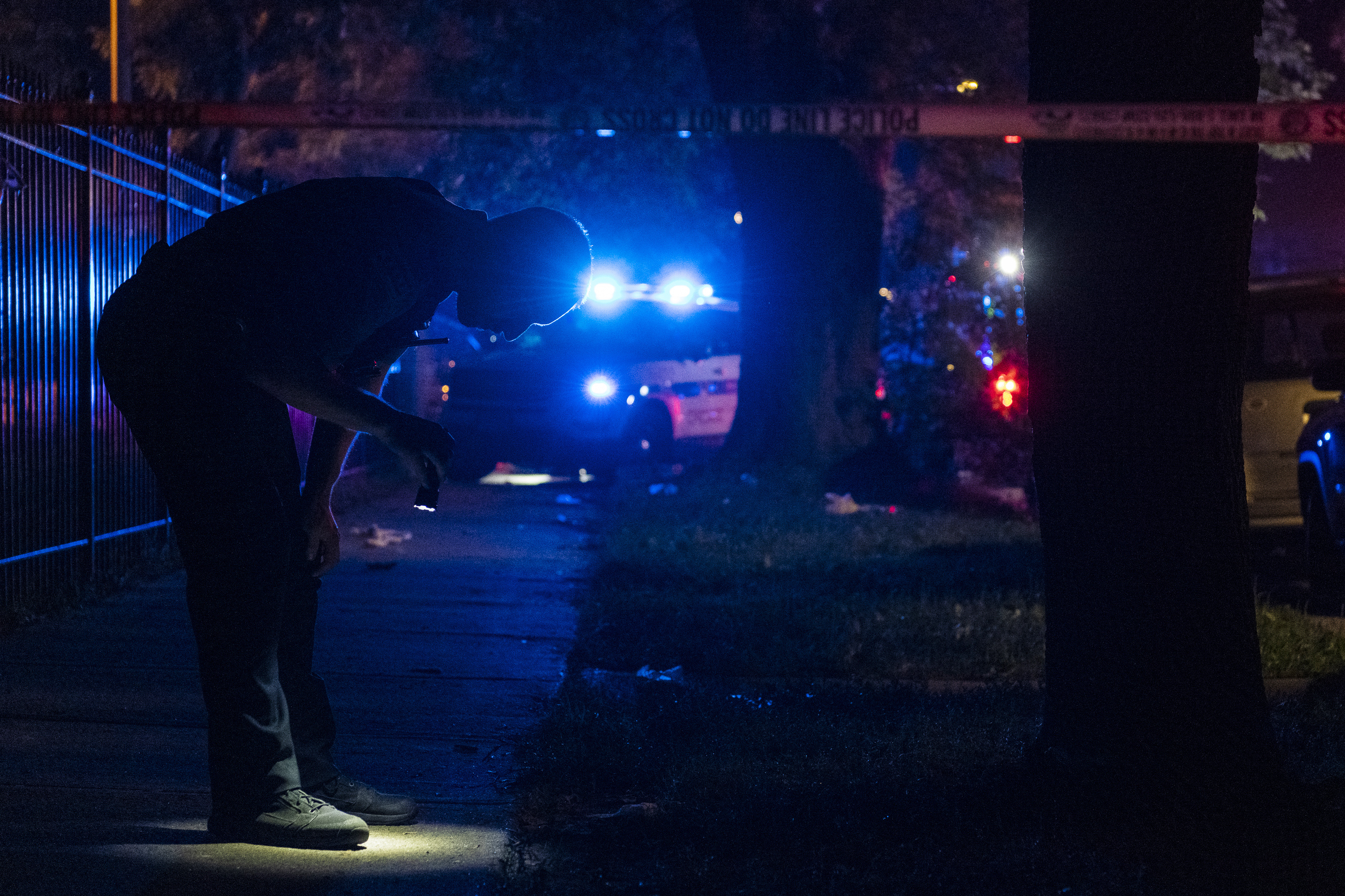 Chicago police investigate the scene where 8 people were shot, four of them fatally, in the Englewood neighborhood of Chicago on Saturday, July 4, 2020. A detailed report from the University of Illinois at Chicago reveals the strain and trauma that many frontline violence prevention workers face as they try to combat gun violence in the Chicago neighborhoods. (Tyler LaRiviere—AP)