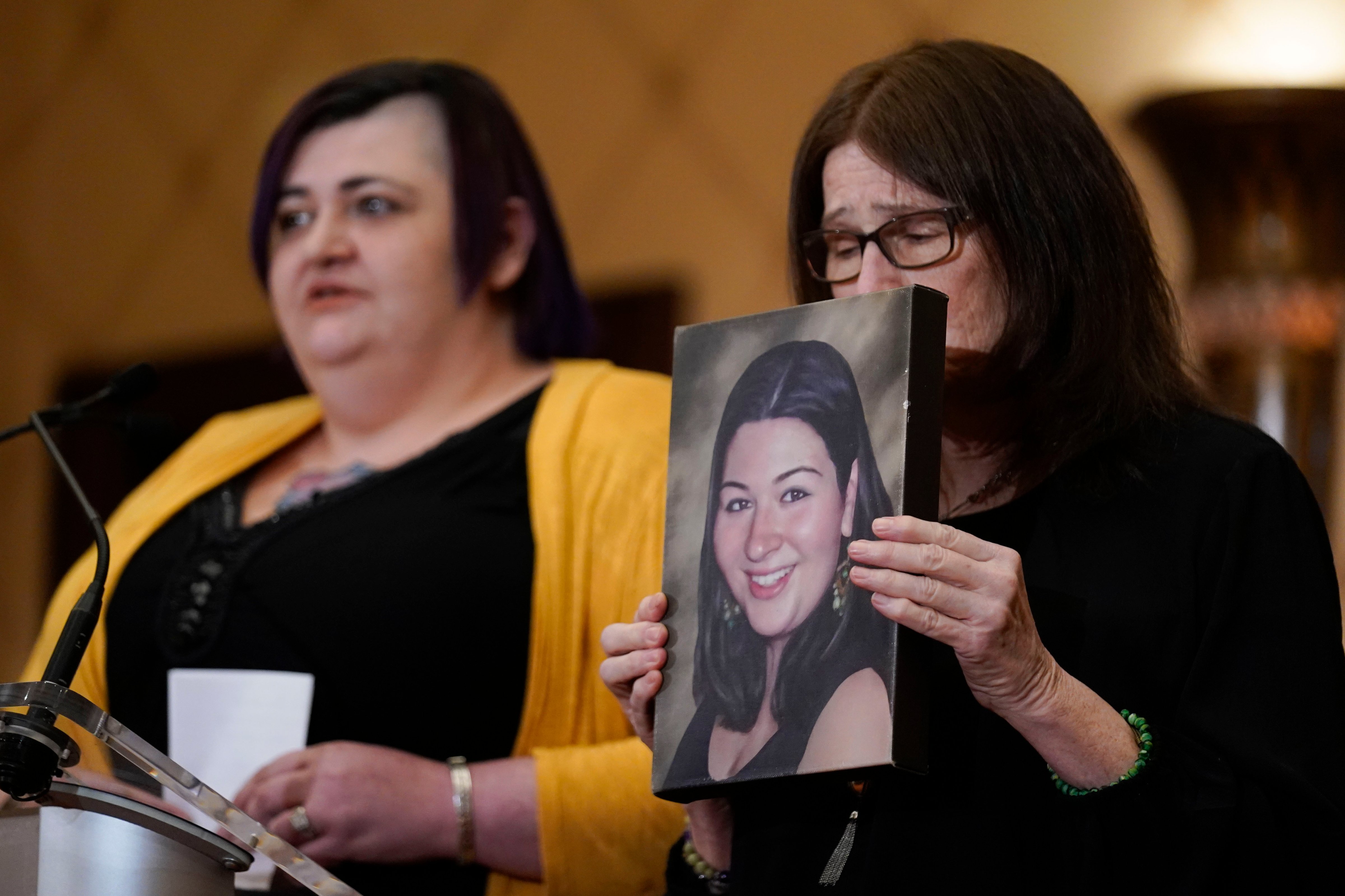 Hannah D'Avino, left, and Mary D'Avino display a picture of Rachel D'Avino, who was killed in the Sandy Hook school shooting, during a news conference in Trumbull, Conn., on Feb. 15, 2022. (Seth Wenig—Associated Press)