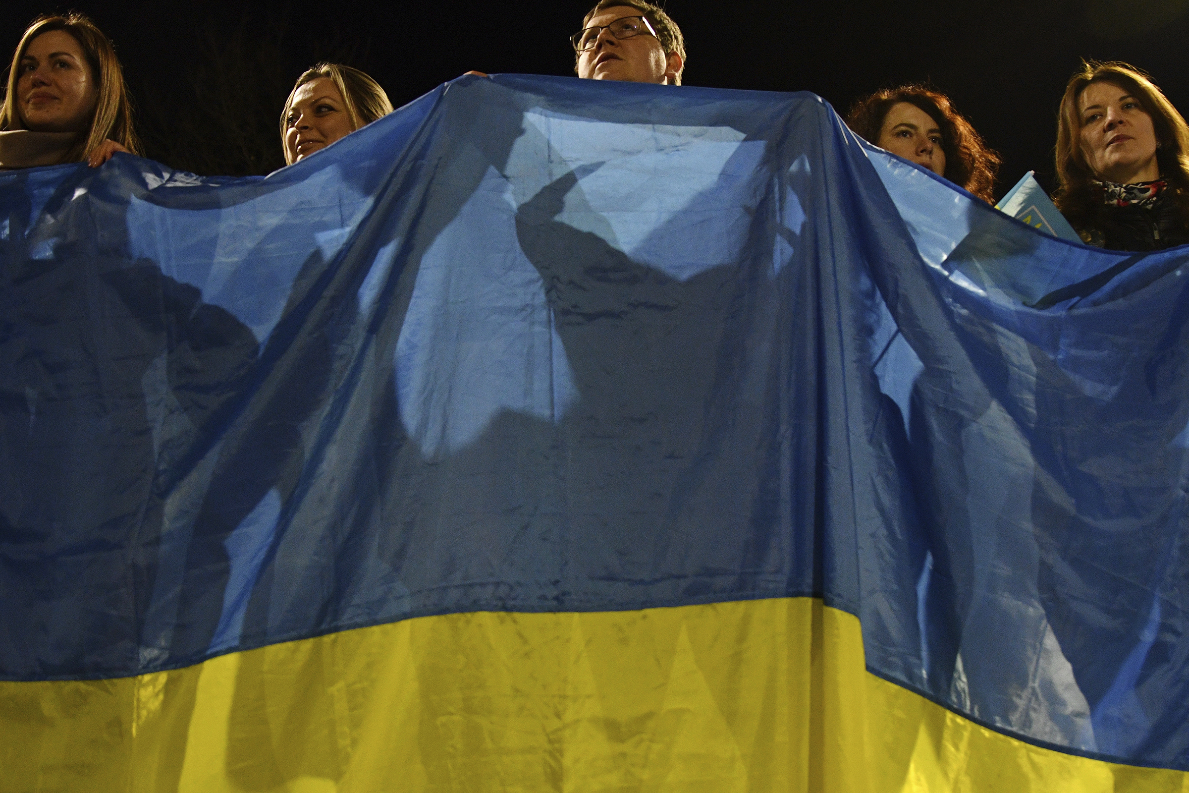 People wave a huge Ukrainian national flag during an action in support of their country in Kramatorsk, Ukraine, Wednesday, Feb. 23, 2022. (Andriy Andriyenko—AP)