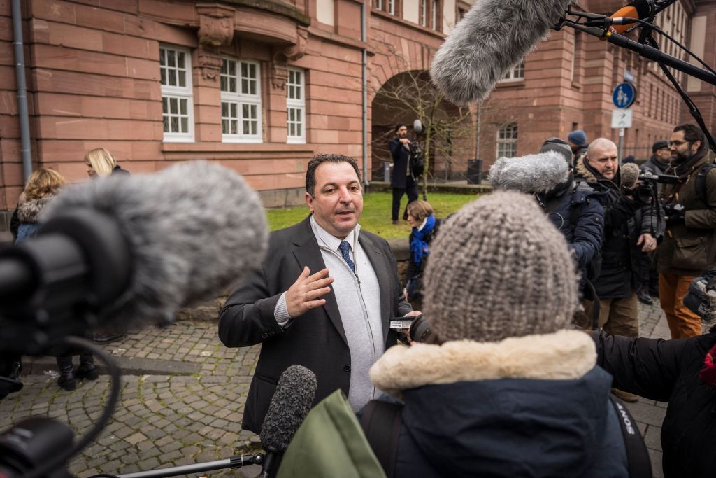 Syrian lawyer and human rights activist Mazen Darwish (center) talks to journalists outside the courthouse where former Syrian intelligence officer Anwar Raslan stood on trial in Koblenz, Germany, on Jan. 13, 2022 (Bernd Lauter—AFP/Getty Images)
