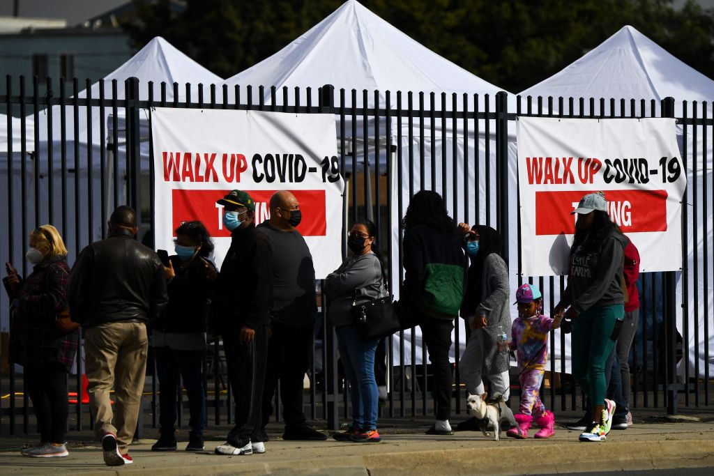 People wear face masks as they wait in line to receive testing for both rapid antigen and PCR Covid-19 tests at a Reliant Health Services testing site in Hawthorne, California on January 18, 2022. (Patrick T. Fallon-AFP))