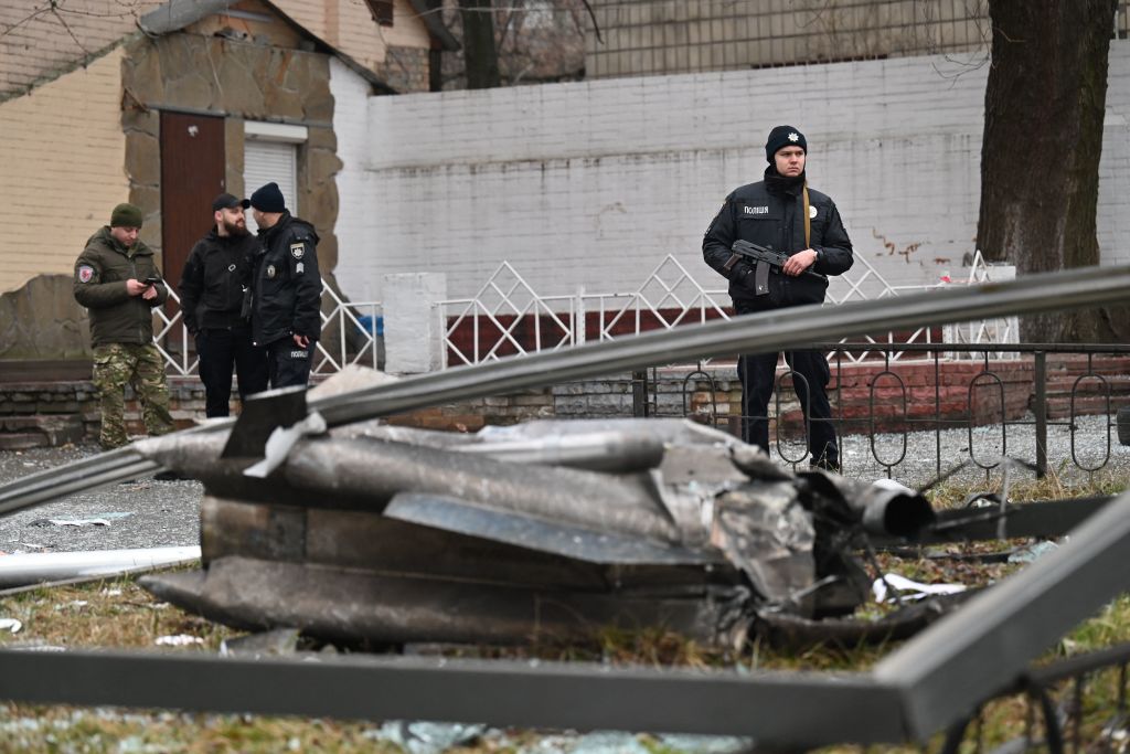 A police officer stands by the remains of a shell in Kyiv on Feb. 24, 2022. (SERGEI SUPINSKY/AFP via Getty Images)