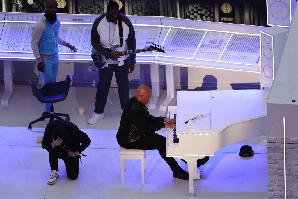 Eminem takes a knee as he performs with Dr. Dre and others during the halftime show of Super Bowl LVI.