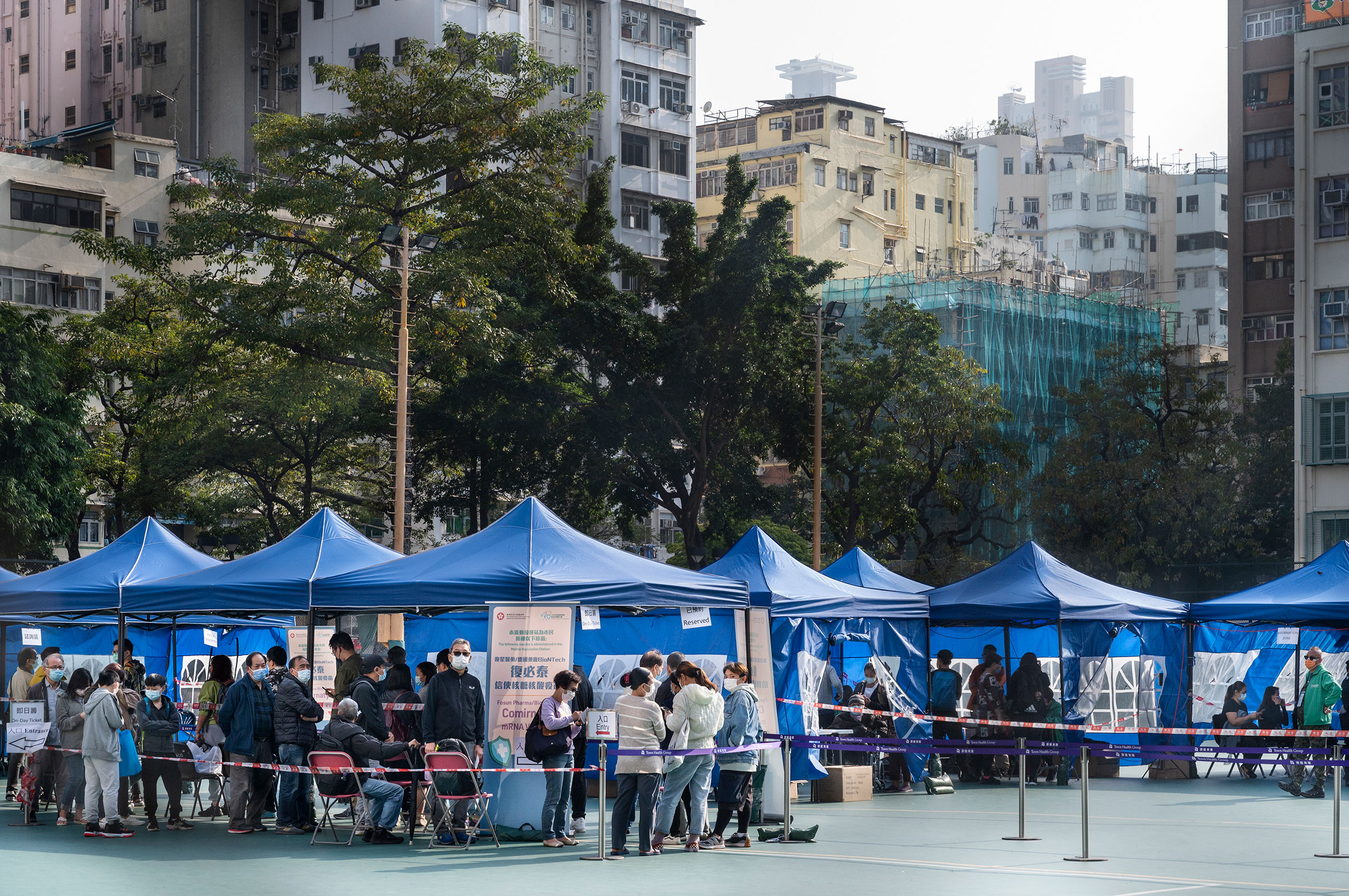 Residents wait to receive a Pfizer-BioNTech COVID-19 vaccine at a mobile vaccination station temporarily set-up for elderly residents and walk-in service in Hong Kong on Jan. 15, 2022. (Miguel Candela—SOPA Images/LightRocket/Getty Images)