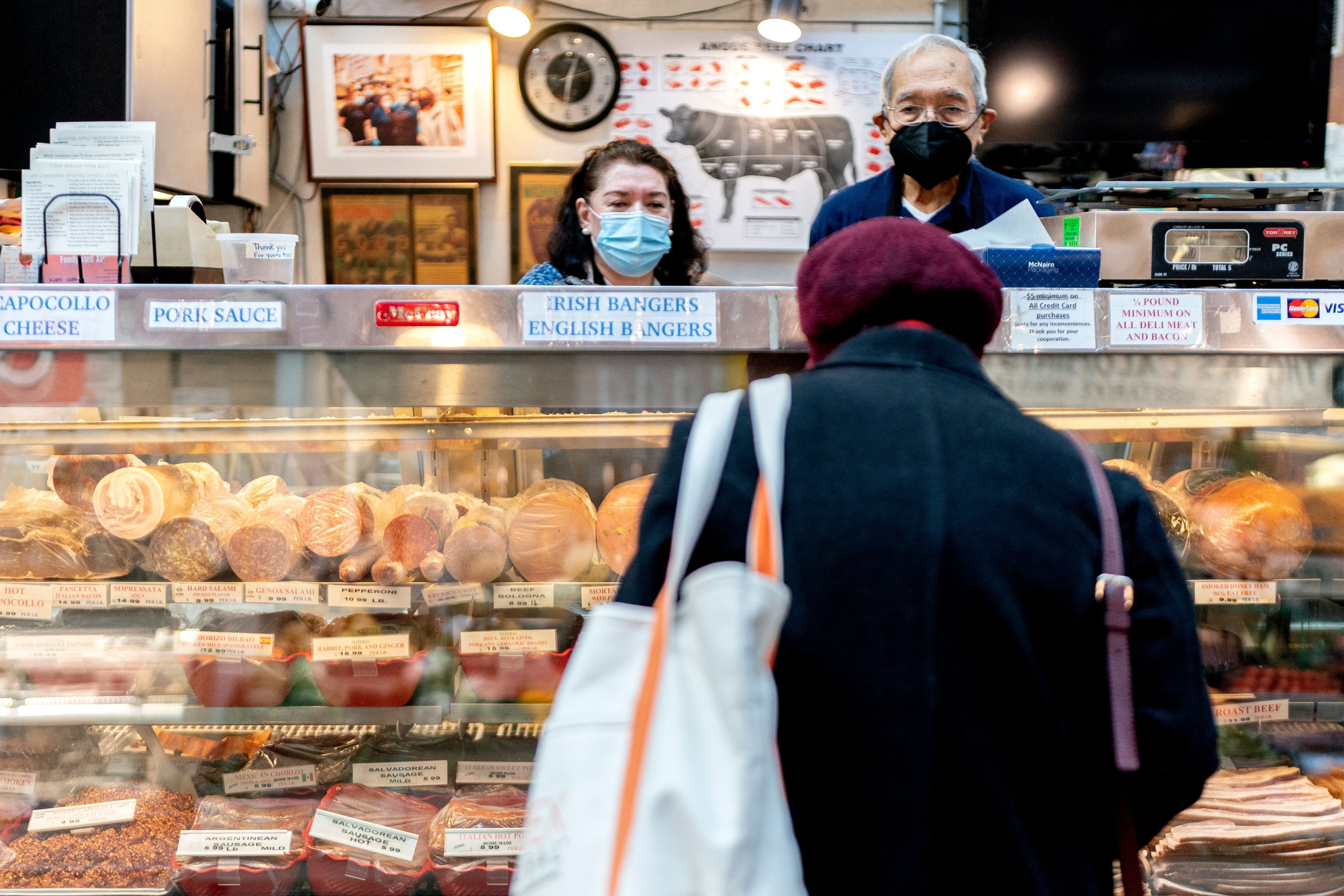 Employees assist a customer at Canales Quality Meats in Eastern Market in Washington, DC, on Feb. 8, 2022. (Stefani Reynolds—AFP/Getty Images)
