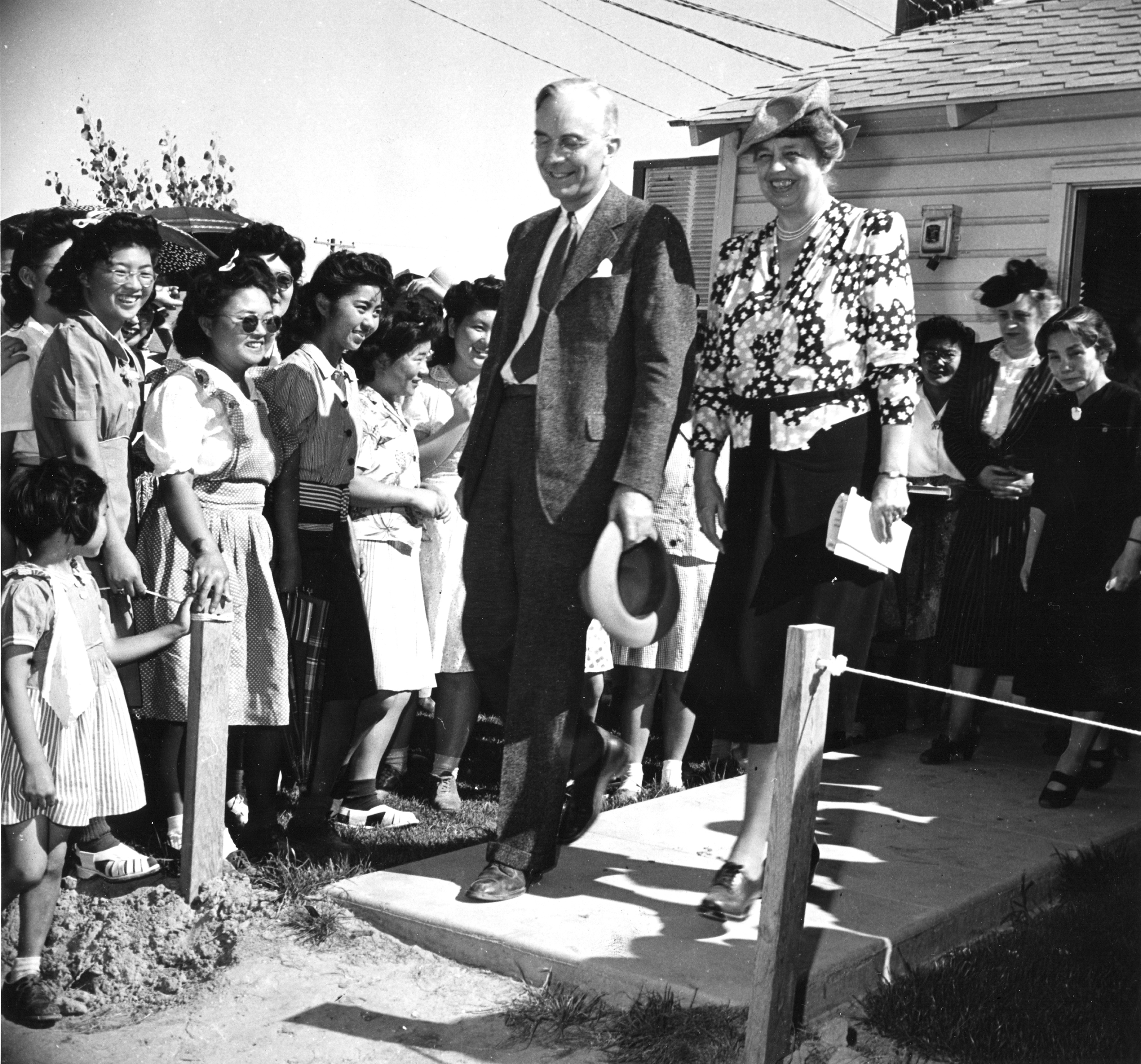 Japanese Americans at the Gila River Relocation Center in Pinal County, Ariz. greet First Lady Eleanor Roosevelt and Dillon S Myer, director of the War Relocation Authority, during their tour of the internment camp on Apr. 23, 1943. (Francis Stewart—PhotoQuest/Getty Images)