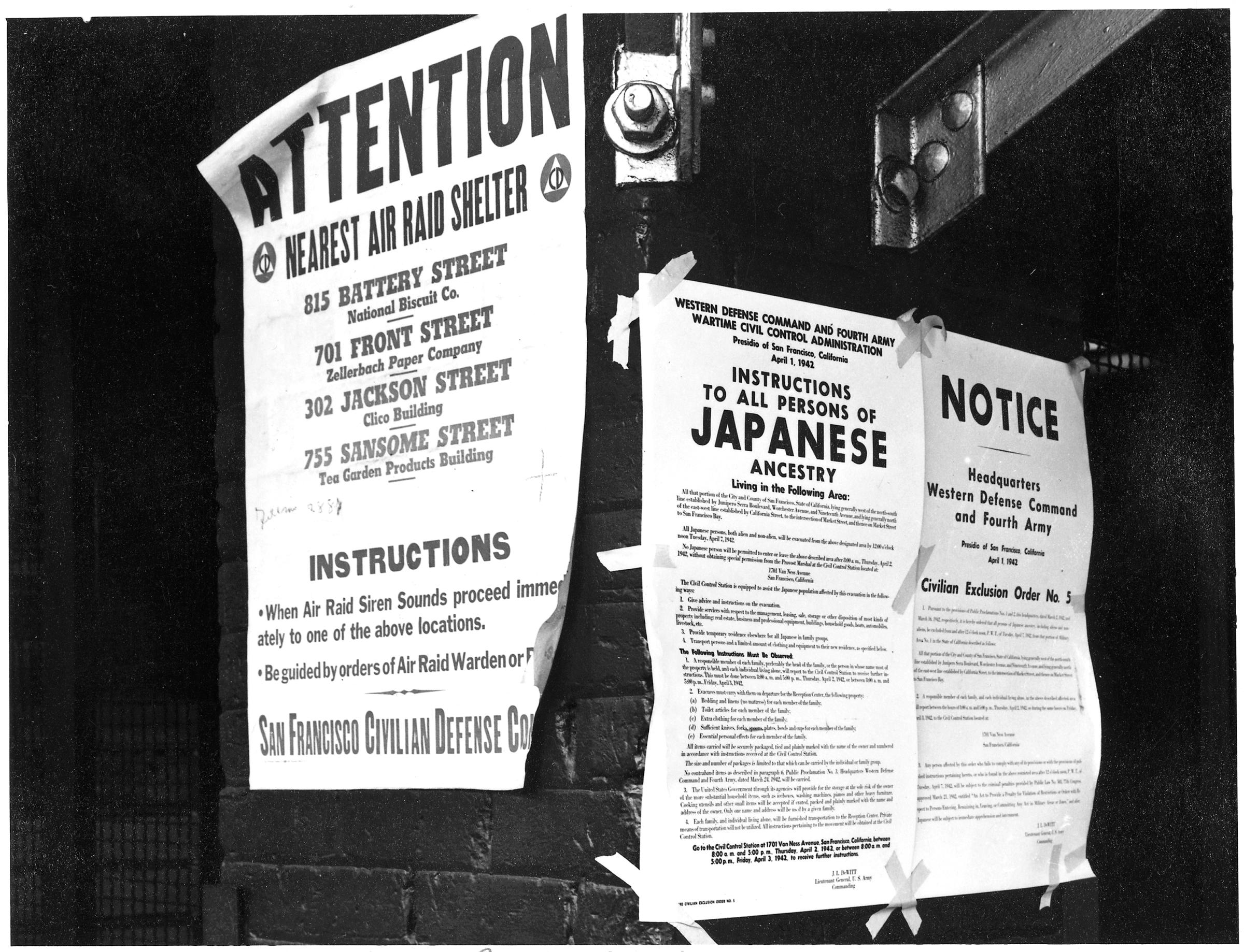 San Francisco, California. On a brick wall beside air raid shelter poster, exclusion orders were posted at First and Front Streets directing removal of persons of Japanese ancestry from first San Francisco section to be affected by evacuation.