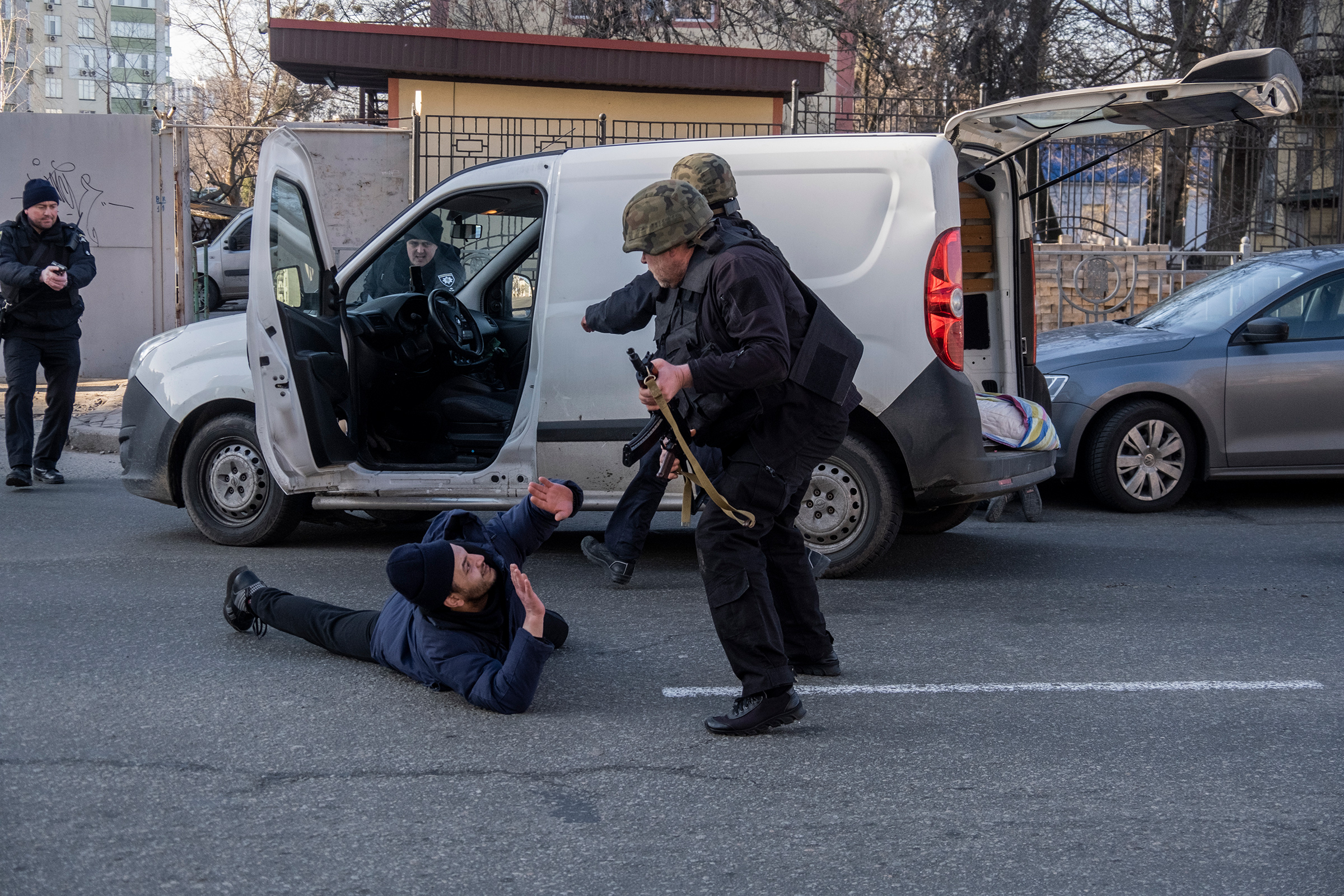 Ukrainian forces detain a man near a building damaged by a Russian rocket attack in Kyiv, Ukraine, on Feb. 26 (Ron Haviv—VII/Redux)