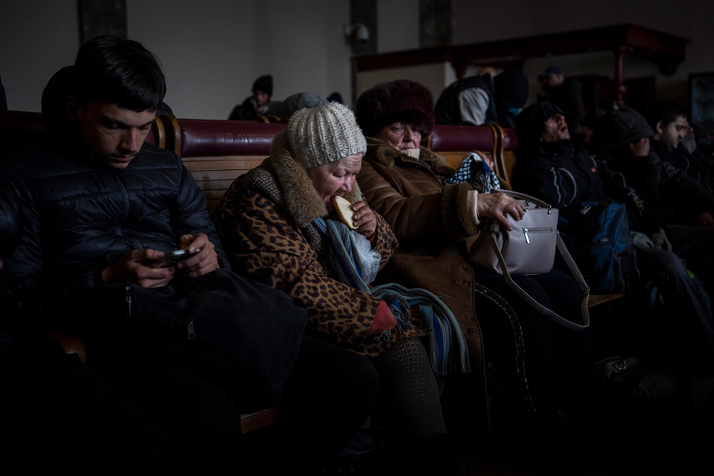 A Ukrainian elderly woman eats a slice of bread inside a crowded Lviv railway station, Feb. 28. Russia's military assault on Ukraine has entered its fifth day, forcing hundreds of thousands of Ukrainians and foreign residents to seek refuge in neighboring countries (Bernat Armangue—AP)