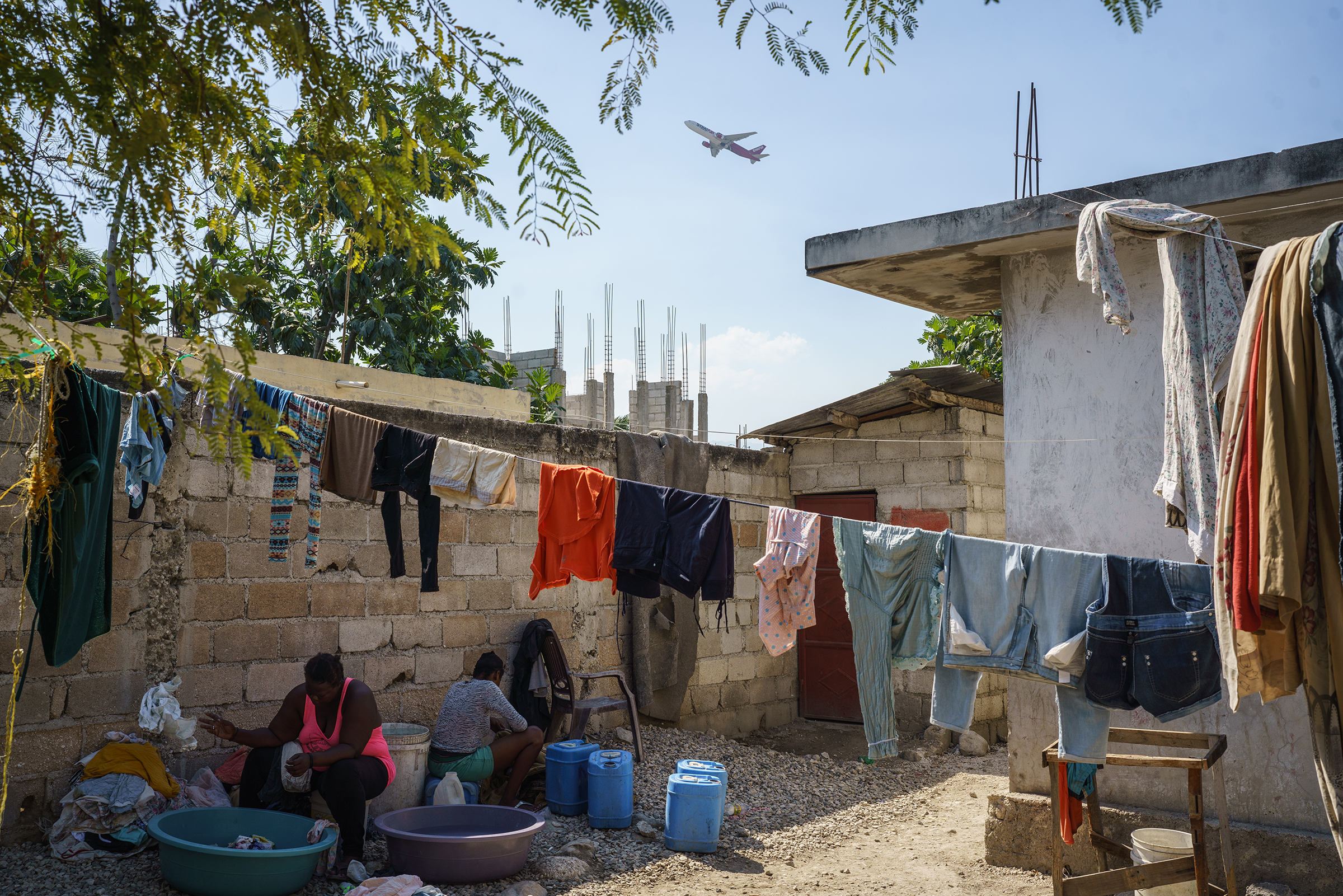 A plane takes off over the courtyard of a house that Mirard Joseph is staying in Port-au-Prince, Haiti on Saturday, January 22, 2022.