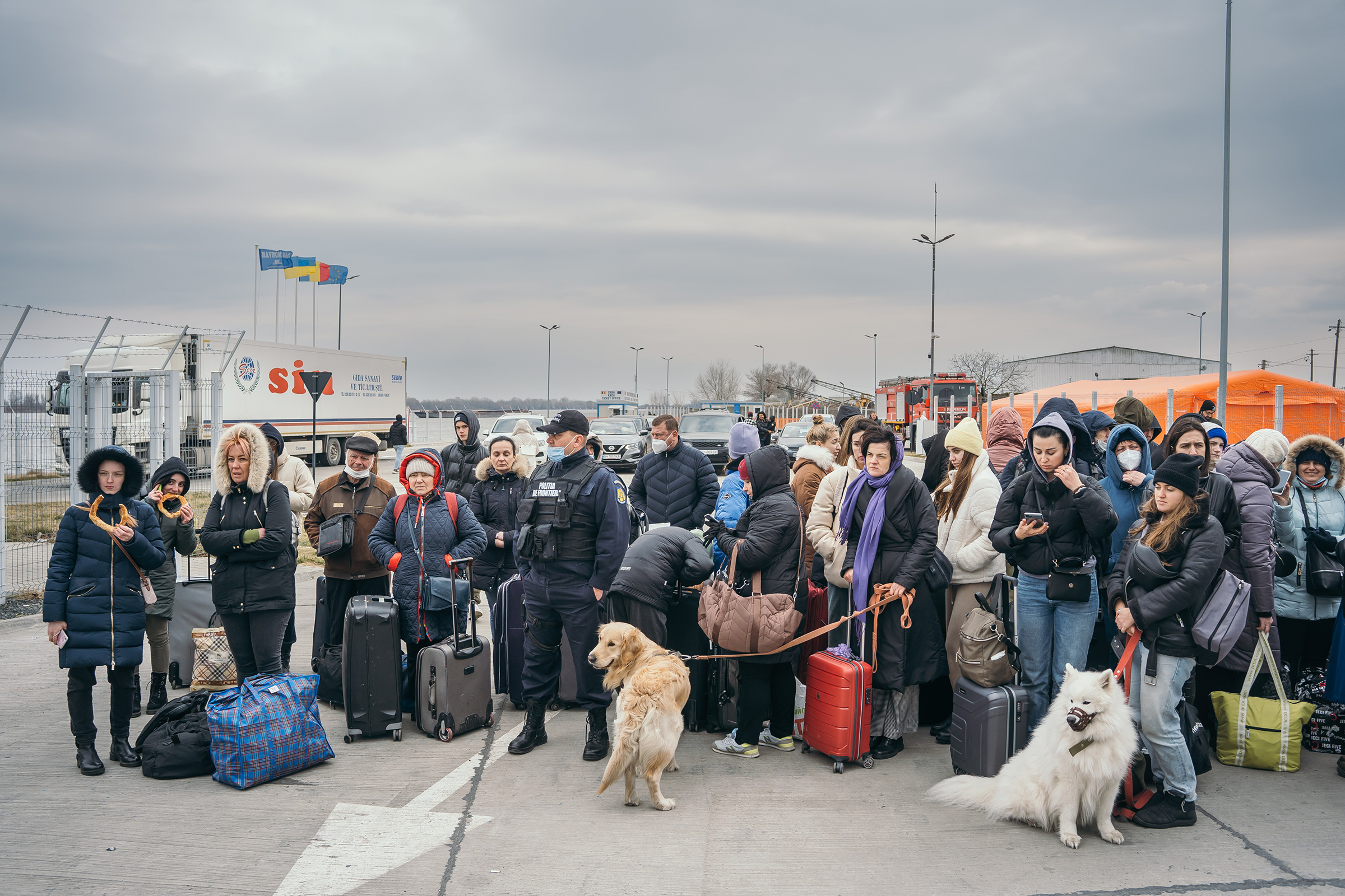 Displaced Ukrainians arrive at a border crossing in Isaccea, Romania, on Feb. 26. In Romania, authorities have dispatched border police, where locals are offering shelter, food, and medicine. (Andrei Pungovschi—Bloomberg/Getty Images)