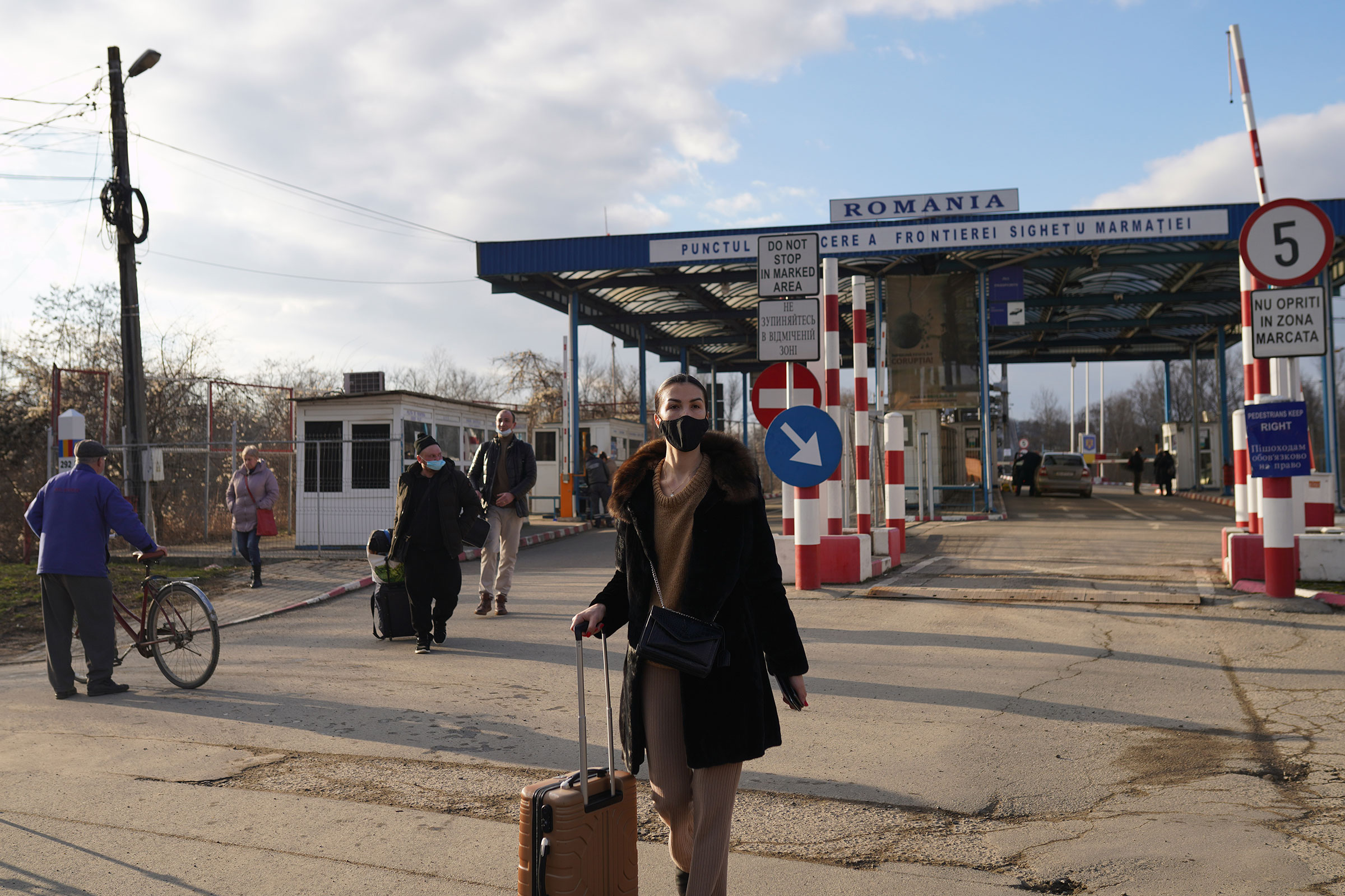 People enter Sighetu Marmatiei, Romania, after having crossed from Ukraine, on Feb. 24, 2022.