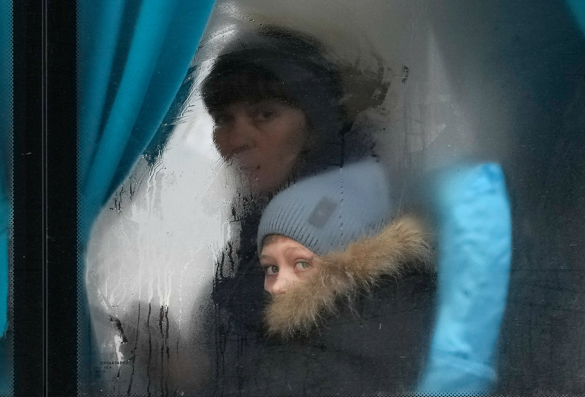 A woman and child look out of the window of a bus as they leave Sievierodonetsk, the Luhansk region, eastern Ukraine, on Feb. 24.