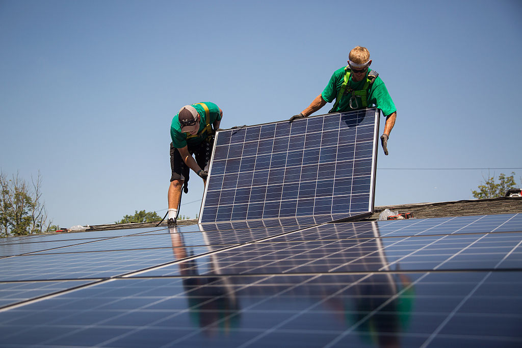 SolarCity Corp. employees install solar panels on the roof of a home in Kendall Park, New Jersey, U.S., on Tuesday, July 28, 2015. (Michael Nagle/Bloomberg—Getty Images)