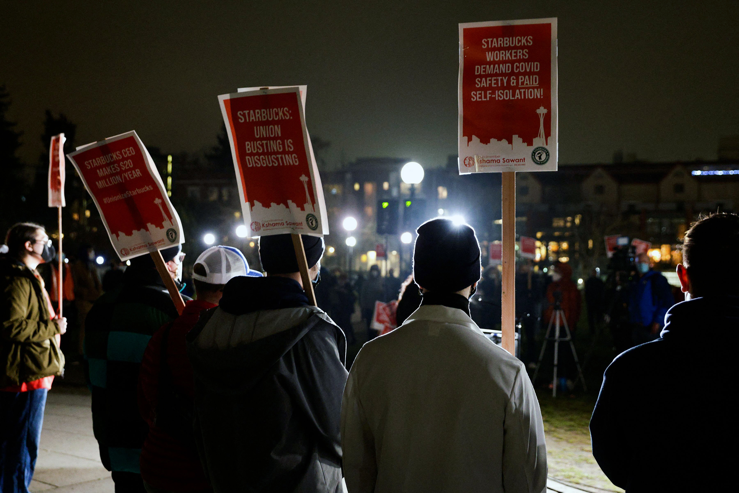 Representatives from local unions hold signs in support of workers of two Seattle Starbucks locations that announced plans to unionize, during an evening rally at Cal Anderson Park in Seattle, Washington, January 25, 2022.