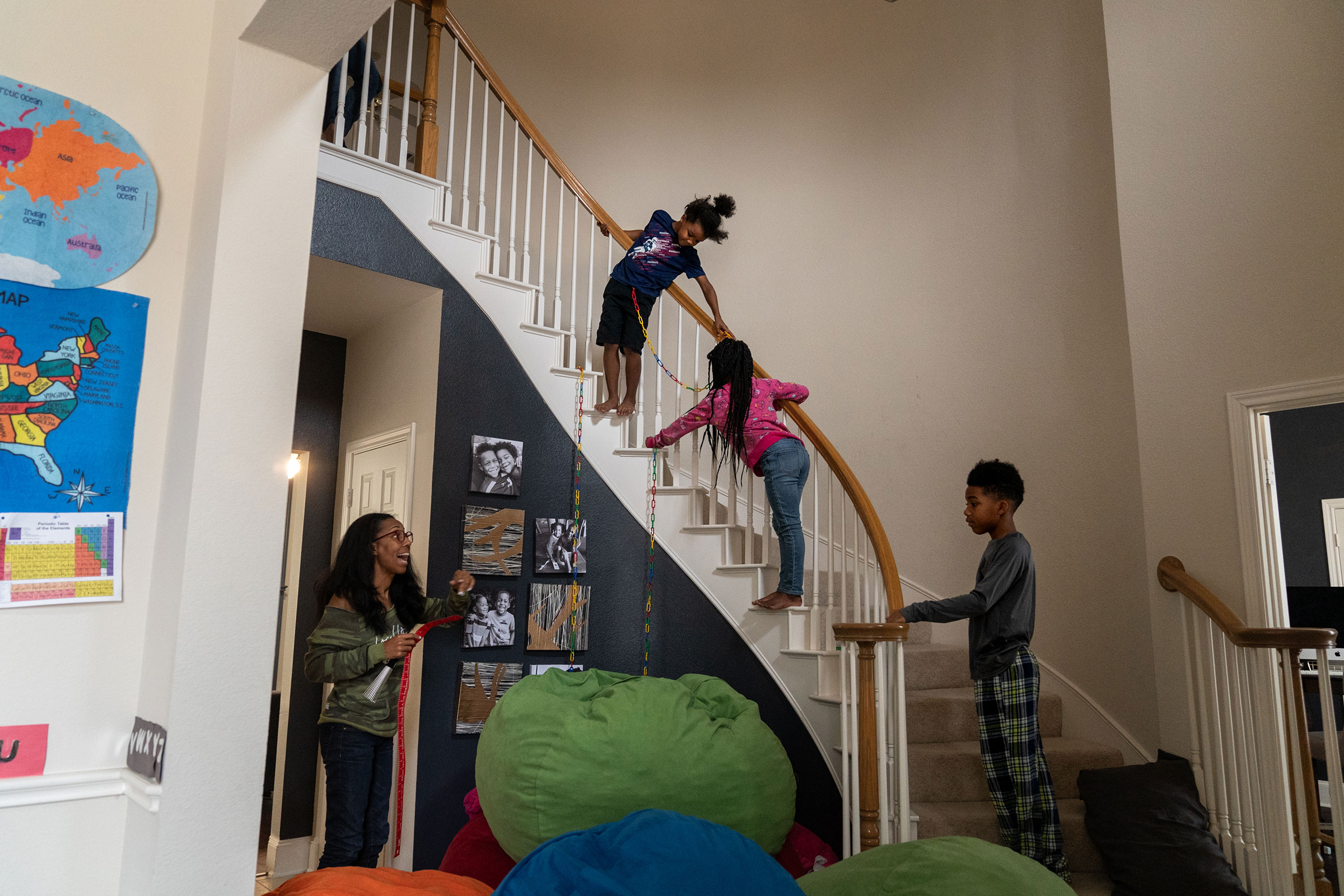 RICHARDSON, TEXAS - February 23, 2022: Brax, 6; Bellamy, 8; and Brice, 10, play on the stairs while their mom Andrea wrangles kids to help with a lesson for the younger siblings. Ilana Panich-Linsman for TIME