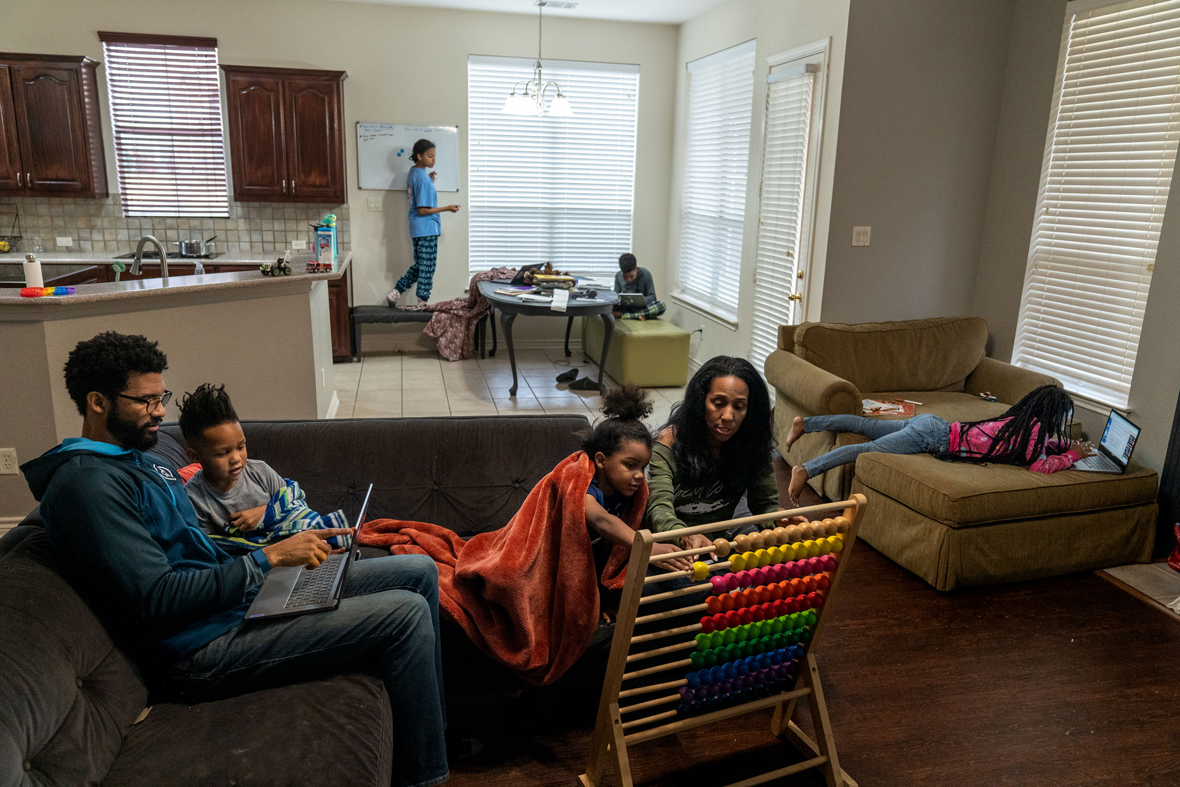 Brian and Andrea Thomas help their two youngest children with their homeschooling lesson at their home in Richardson, Tx. on Feb. 23, 2022. (Ilana Panich-Linsman for TIME)