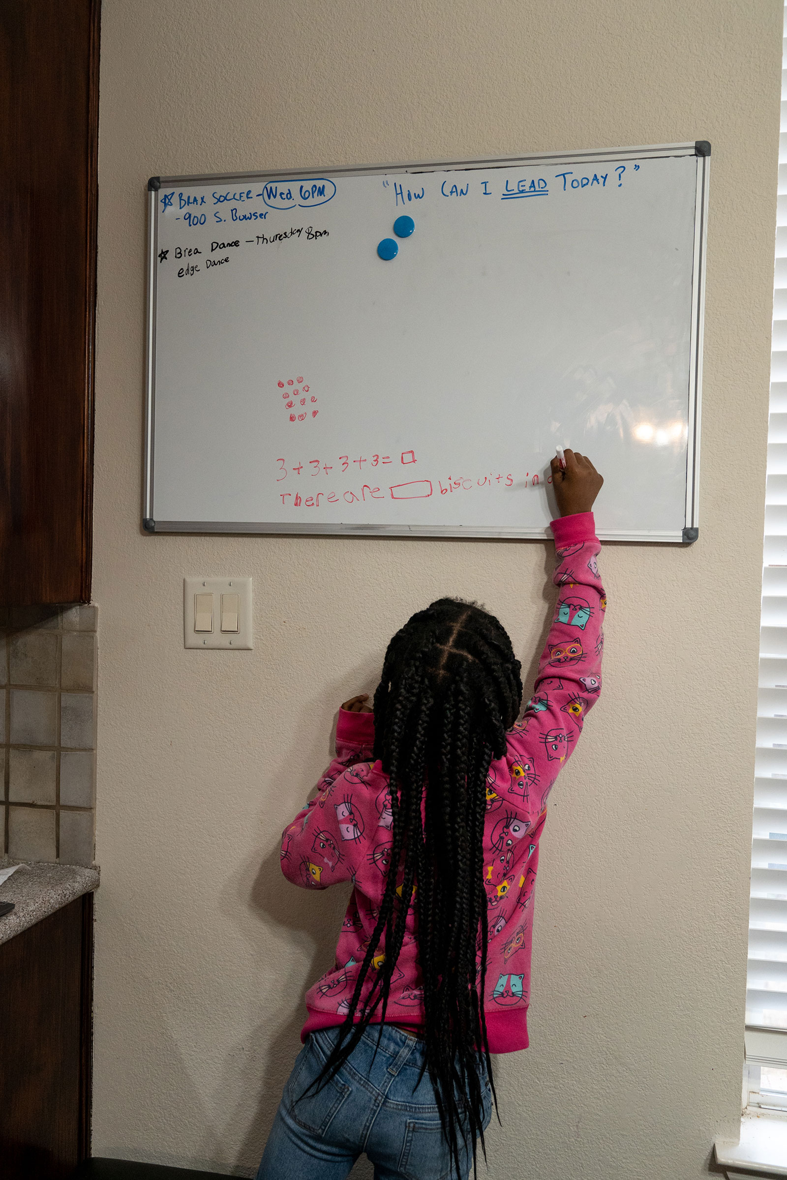 RICHARDSON, TEXAS - February 23, 2022: Bellamy, 8, works out a math problem on a whiteboard in the family's kitchen. Ilana Panich-Linsman for TIME