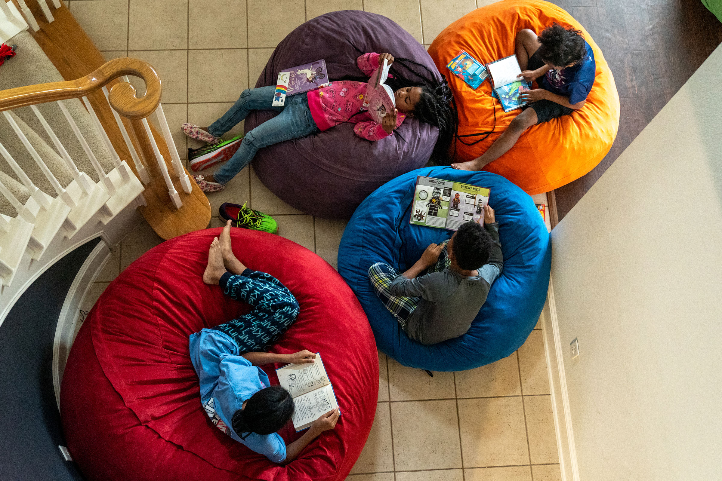 Four of the Thomas siblings read in beanbag chairs in the entryway of the family's home. (Ilana Panich-Linsman for TIME)