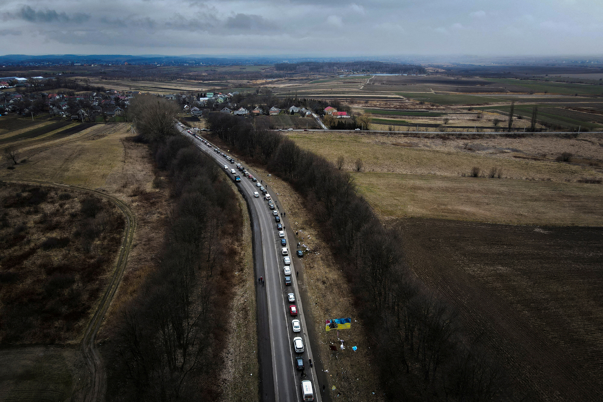 Cars line up on the road to the Shehyni border crossing as people flee to Poland, after Russia launched a massive military operation against Ukraine, outside Mostyska, Ukraine, Feb. 27 (Natalie Thomas—Reuters)